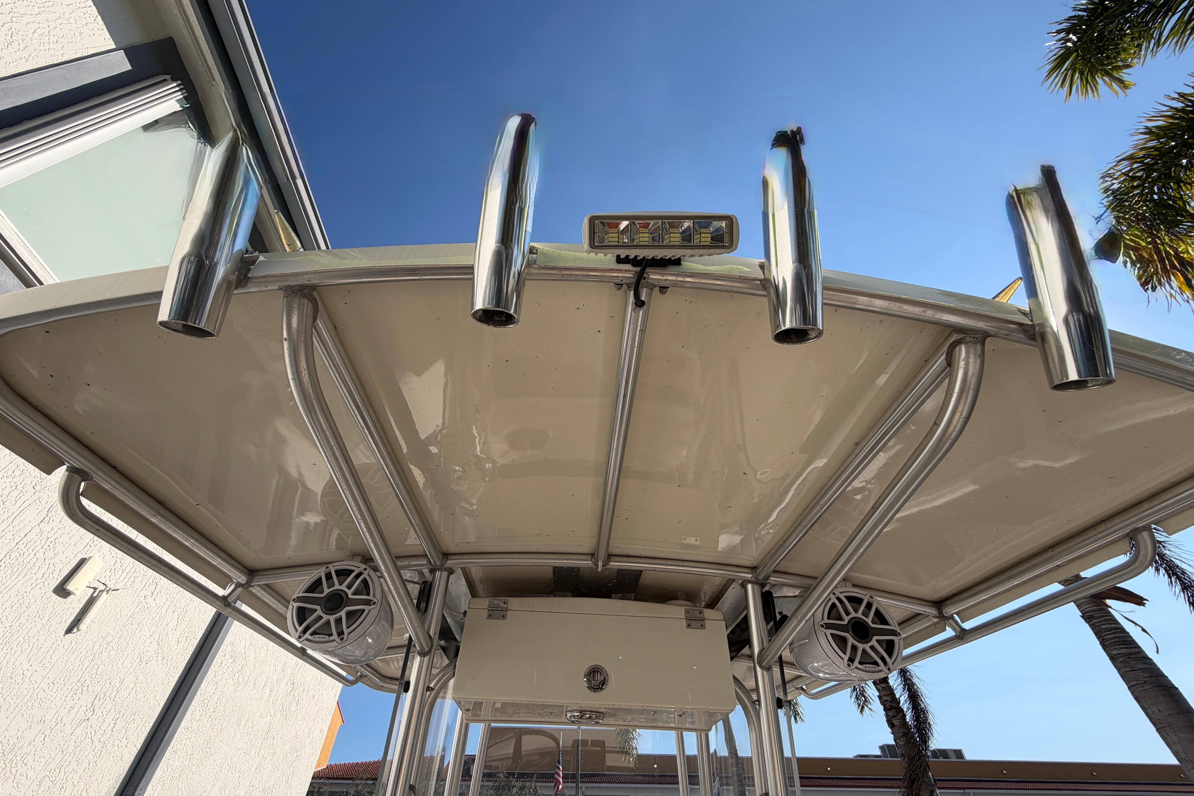 2004 Grady White 273 boat top with rod holders and speakers under clear sky.