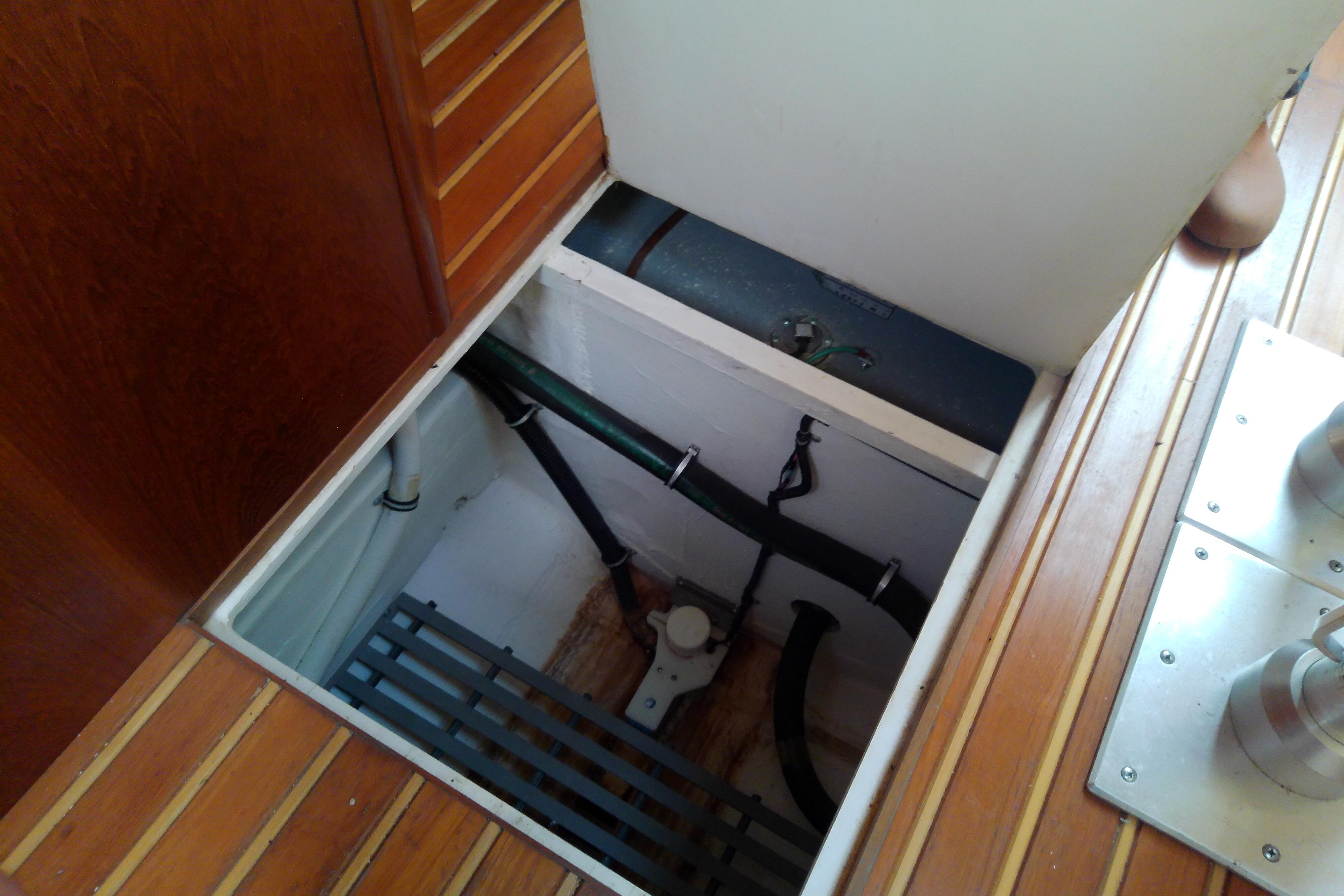 Bilge compartment of 2000 Tiara Yachts 4100 Open, showcasing plumbing and storage.