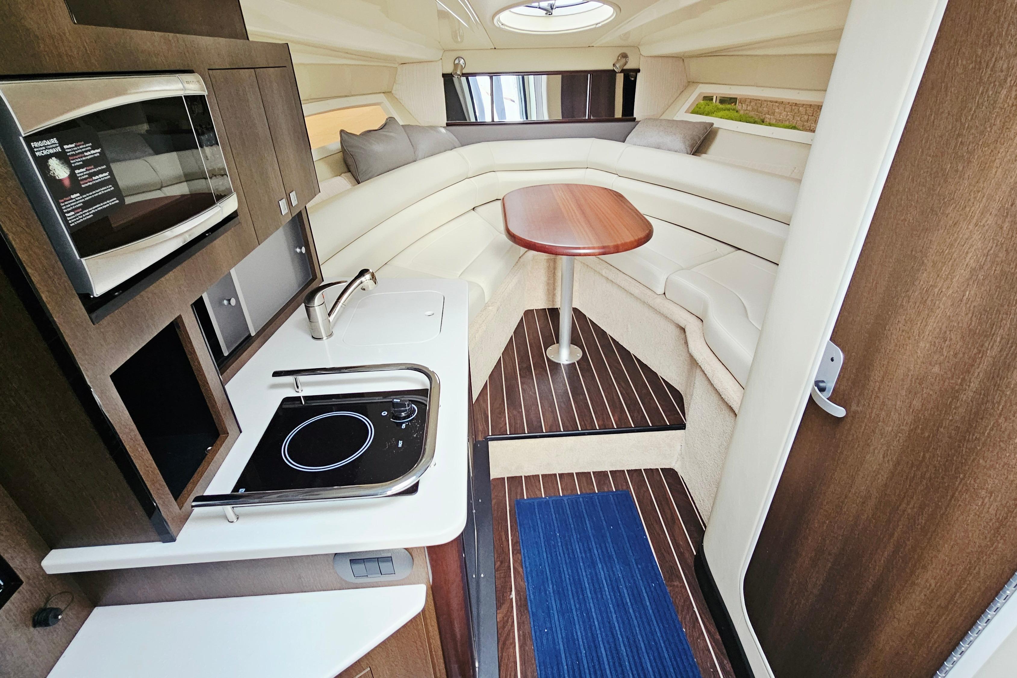 Interior of 2016 Monterey 295 Sport Yacht with kitchenette and seating area.