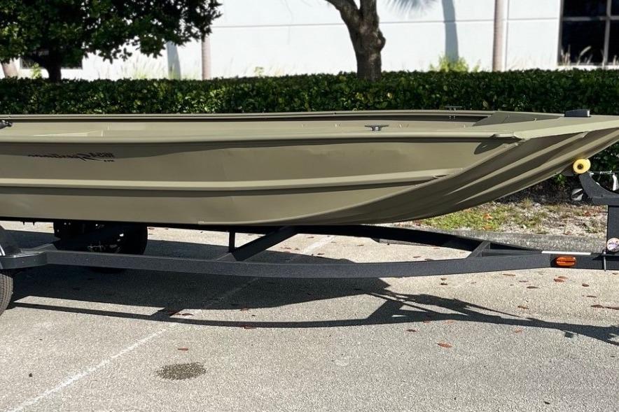 2026 Tracker Grizzly 1654 T Sportsman boat on trailer, parked outdoors.