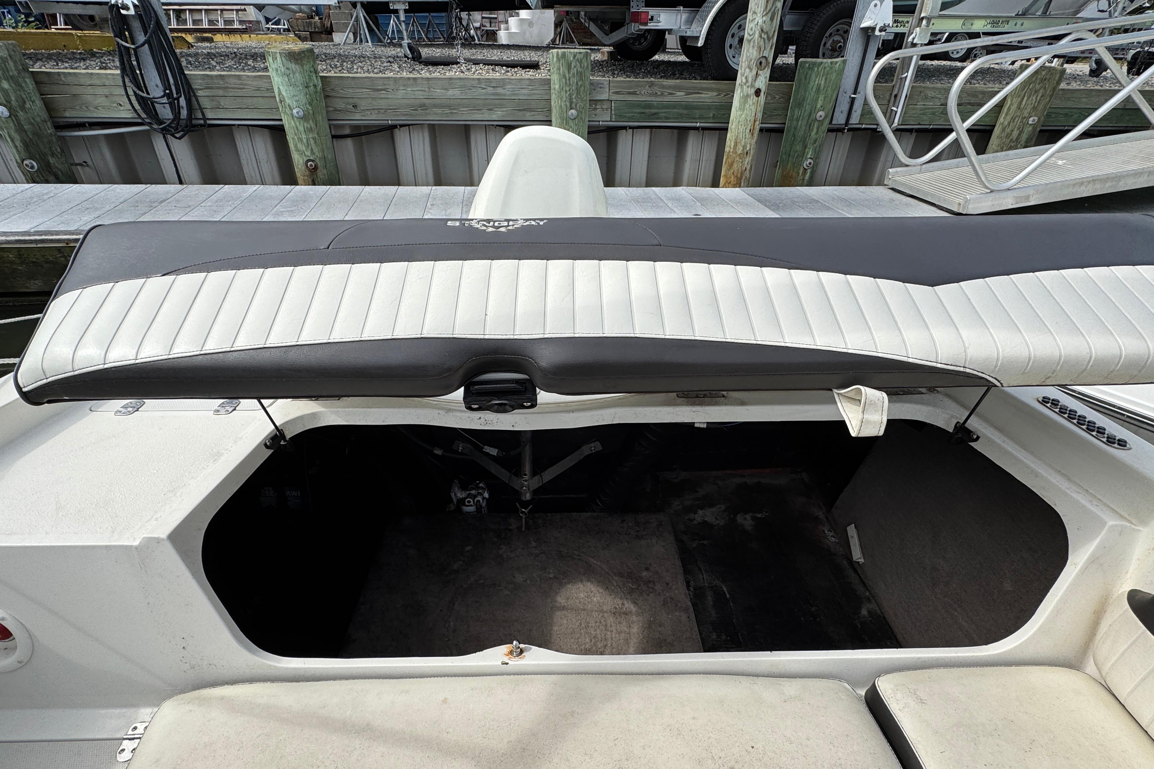 2018 Stingray 204 LR boat with open storage compartment at dock.