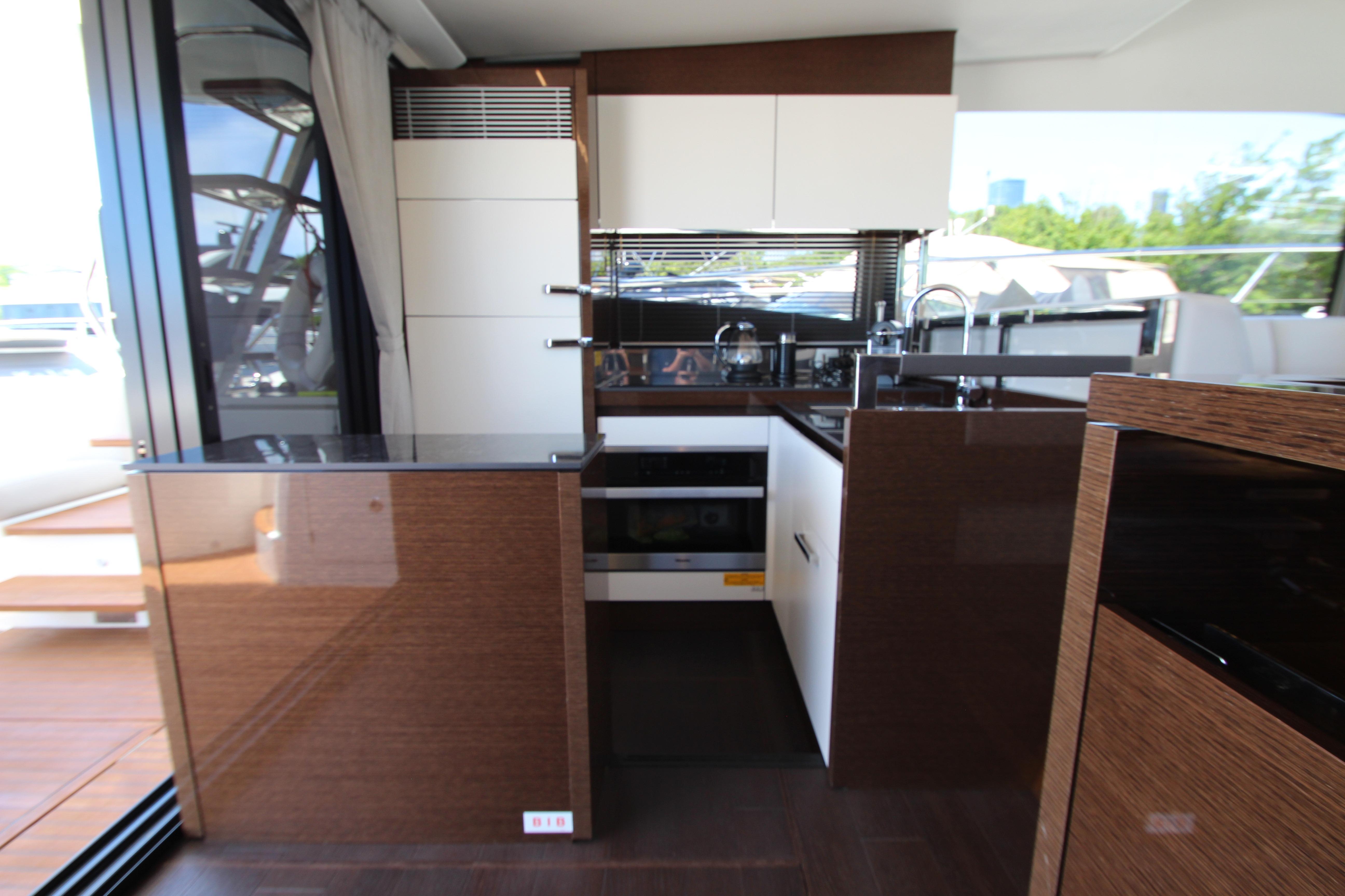 Modern kitchen interior on 2022 Prestige 520 yacht, featuring sleek cabinetry and appliances.