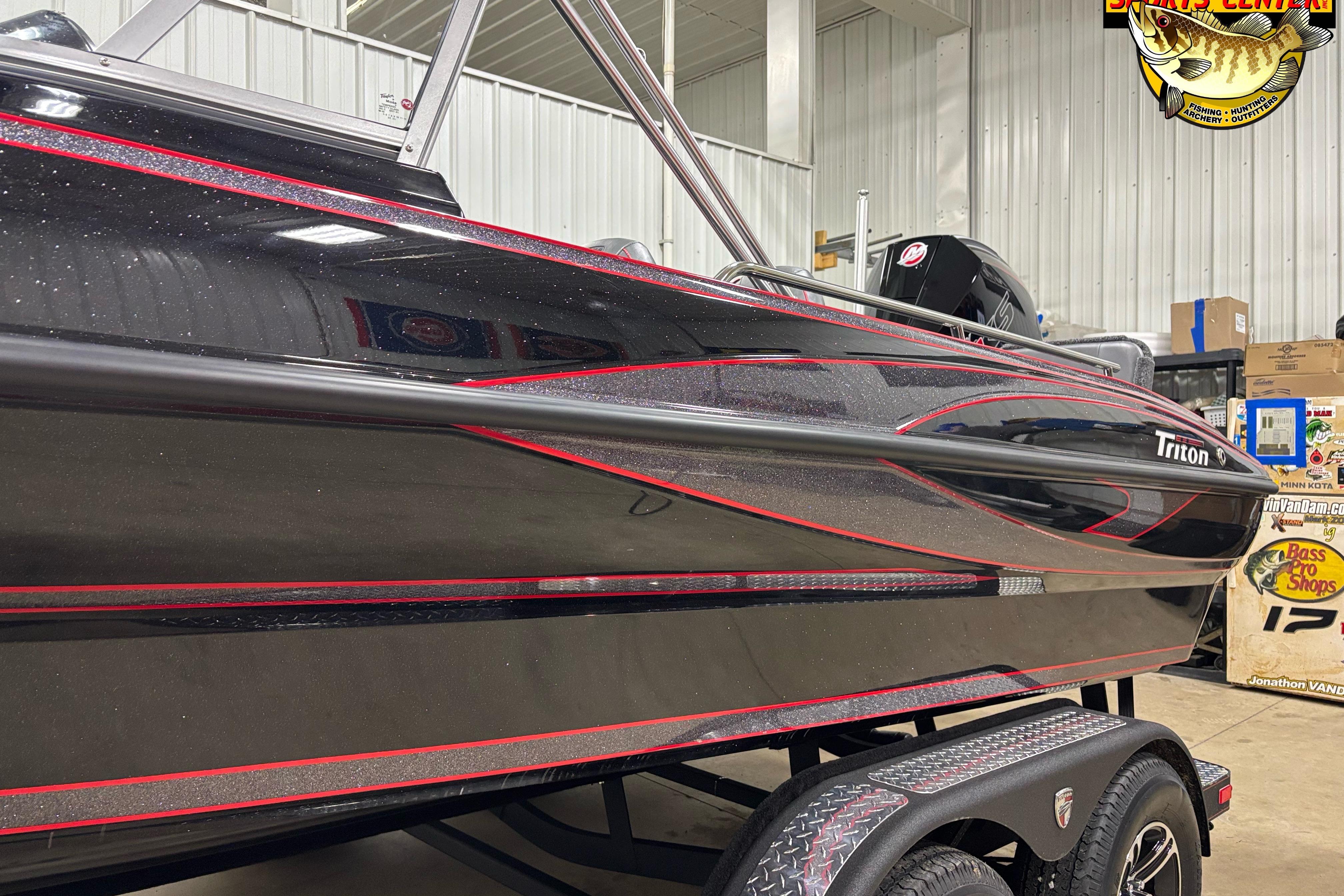 2026 Triton 206 Allure boat with sleek black and red design in showroom.