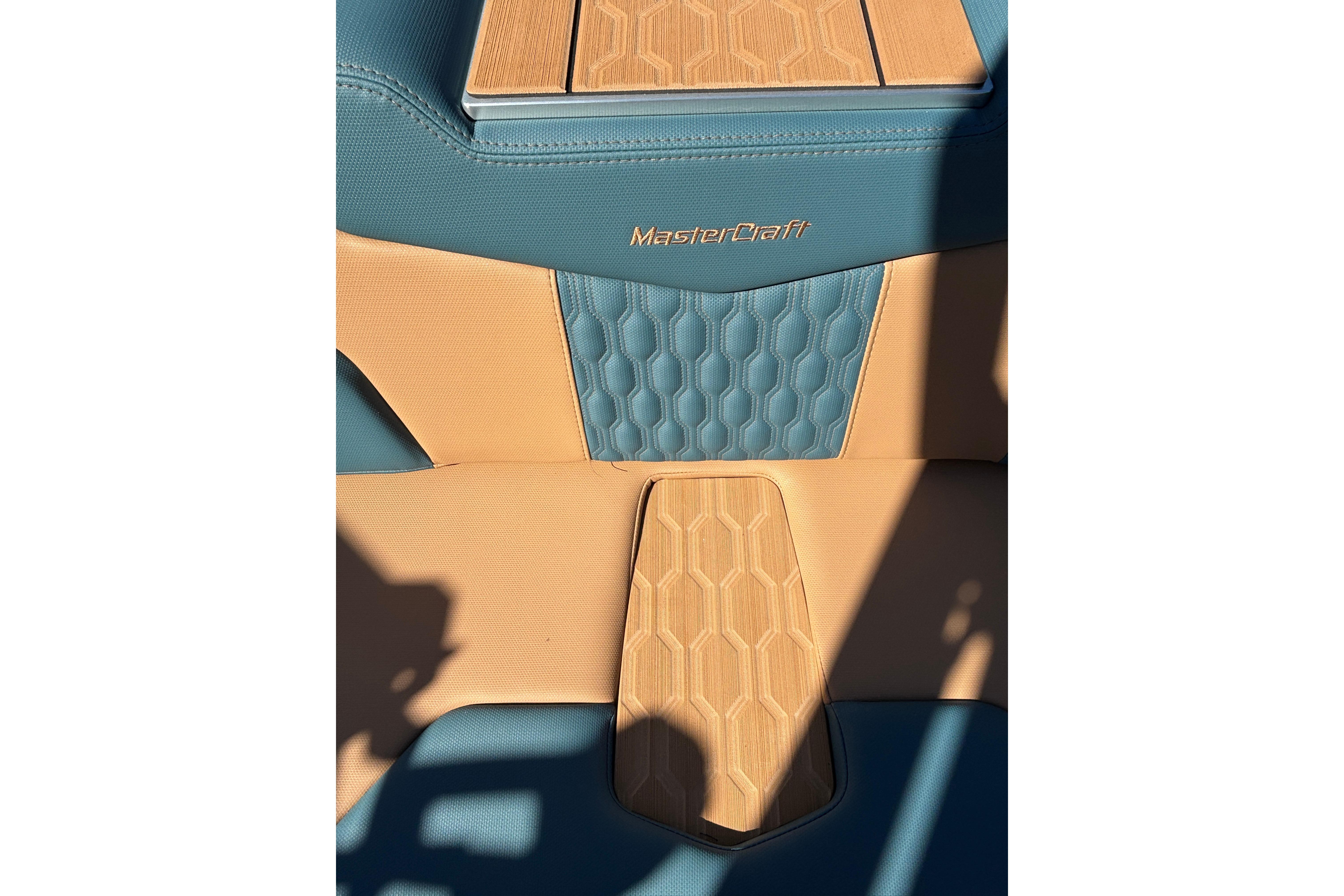 2026 MasterCraft XT24 boat interior with blue and tan hexagonal pattern upholstery.