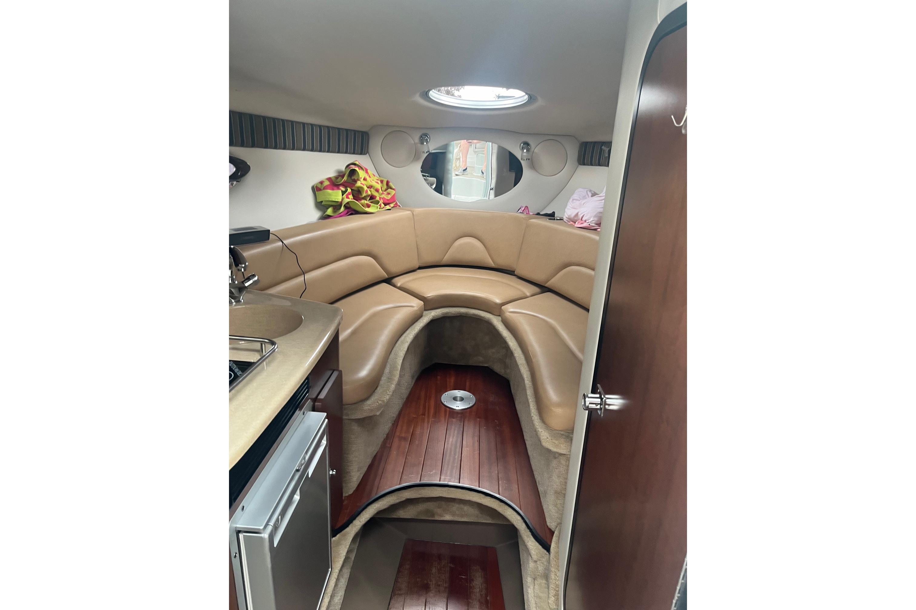 2016 Crownline 264 CR cabin interior with tan seating and kitchenette.