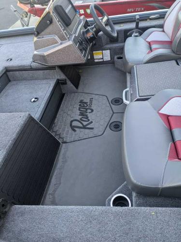 2025 Ranger ALPHA 208 boat interior with gray and red seating, steering console, and branded flooring.