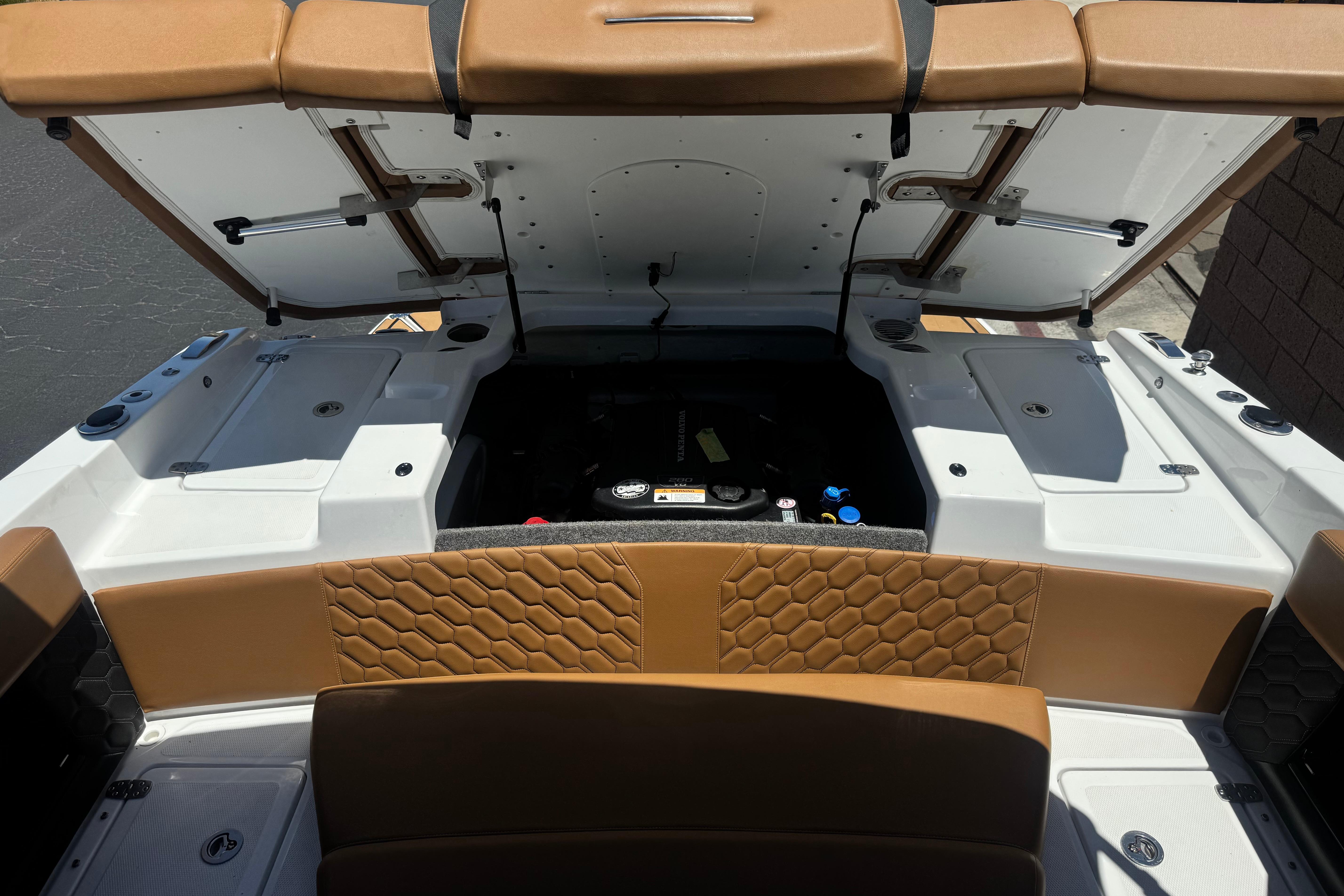 2022 Four Winns H4 boat engine compartment with open hatch and tan seating.