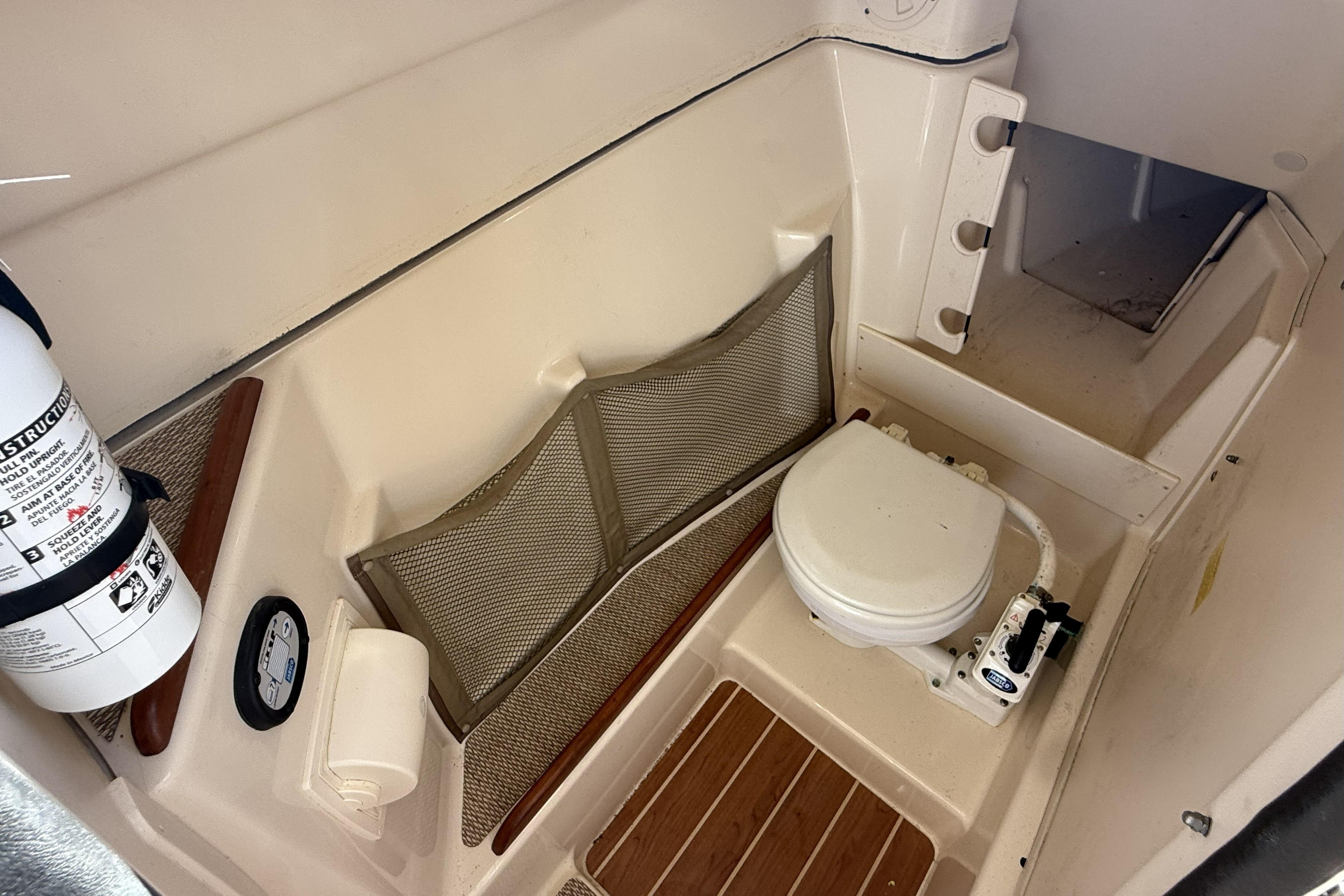 2014 Grady-White Freedom 275 boat interior with toilet and fire extinguisher.