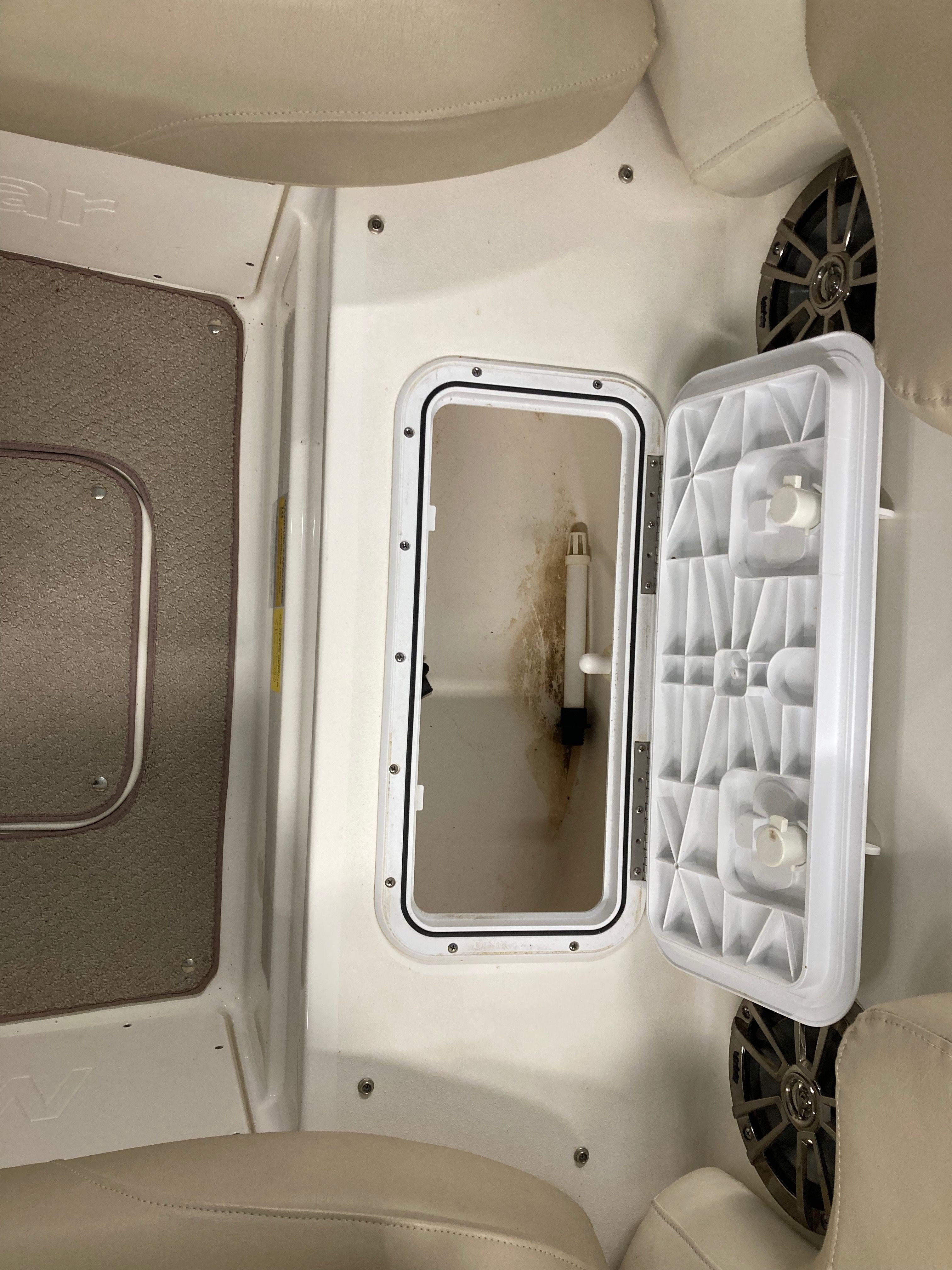 Interior view of a boat with storage compartment and speakers.