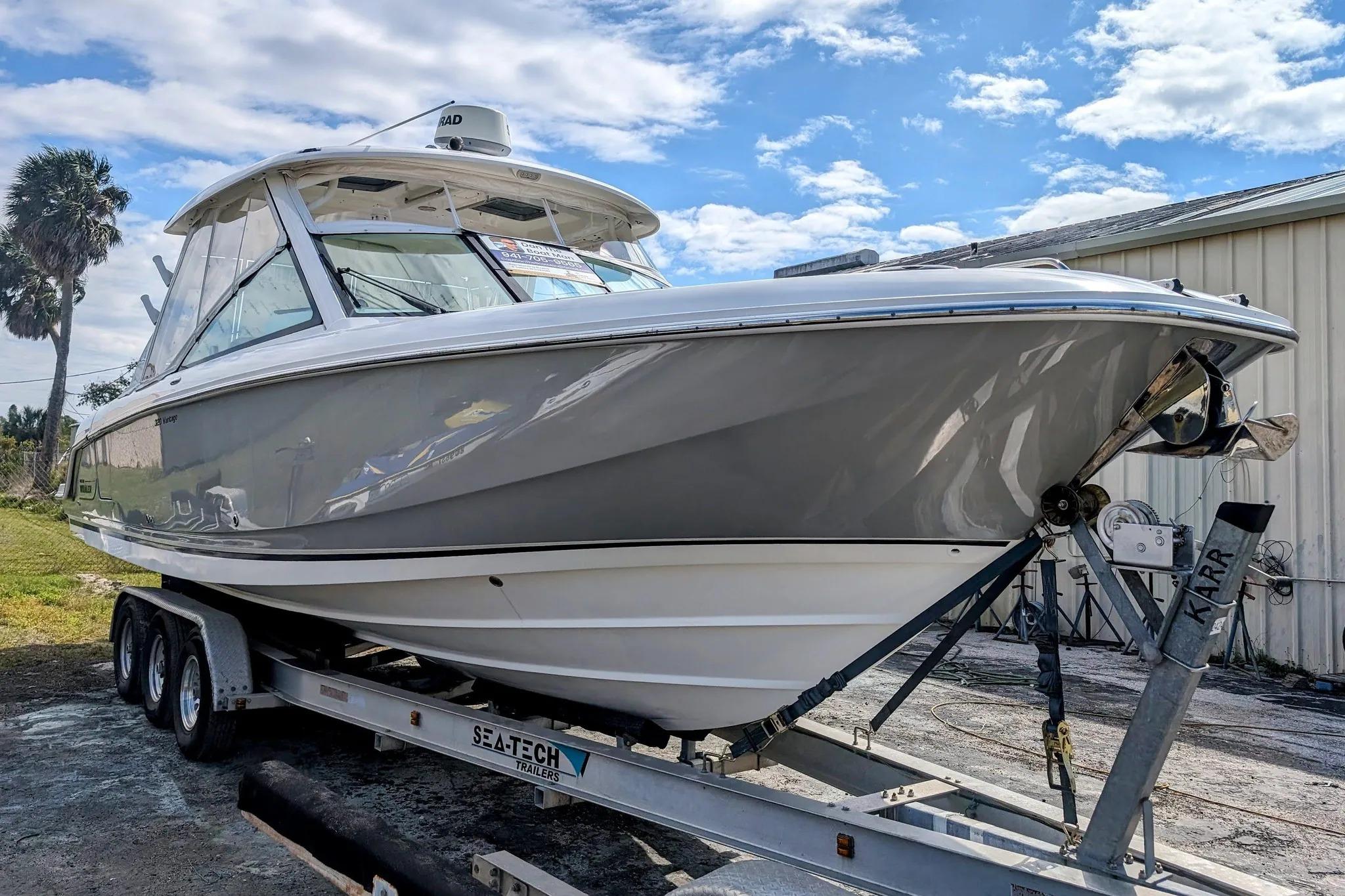 2017 Boston Whaler 320 Vantage boat on trailer, parked outdoors under blue sky.