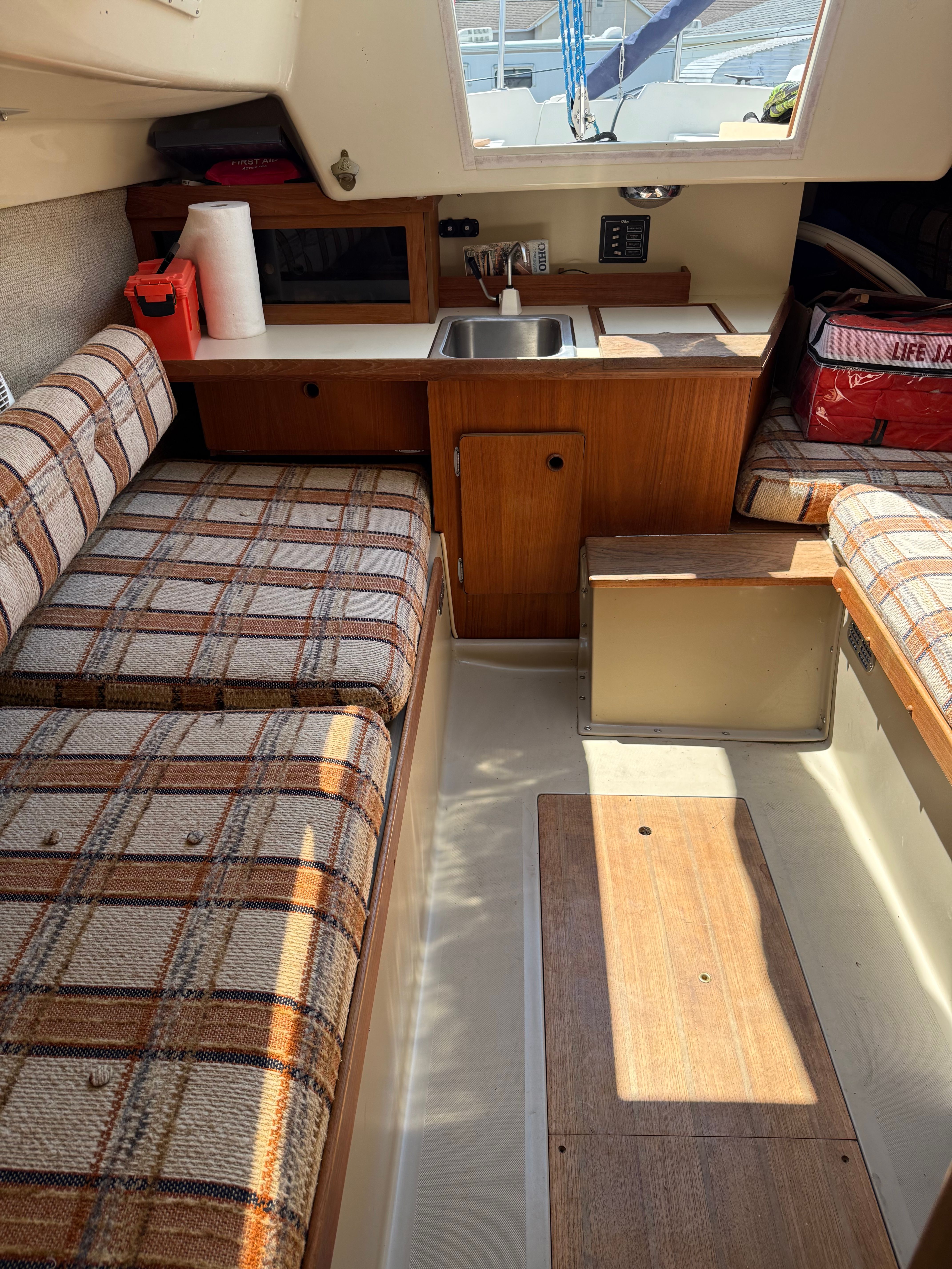 Interior of a 1984 O'Day 25 yacht with kitchen and seating area.