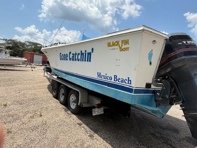1986 Blackfin 27 boat on trailer, labeled "Gone Catchin'," parked at Mexico Beach.