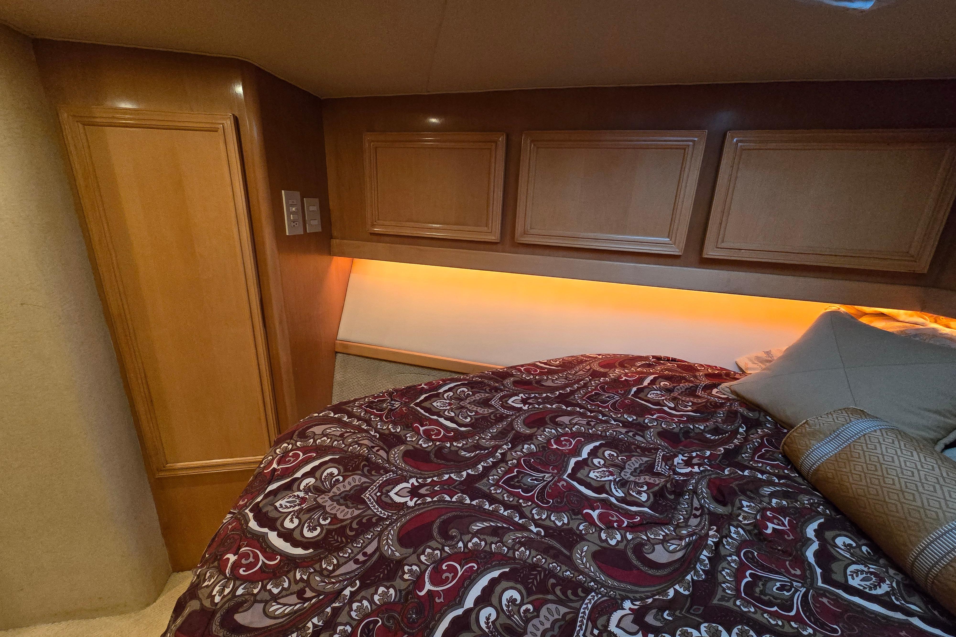 Luxurious cabin interior of 2001 Cavileer 53 Convertible with elegant bedding and warm lighting.