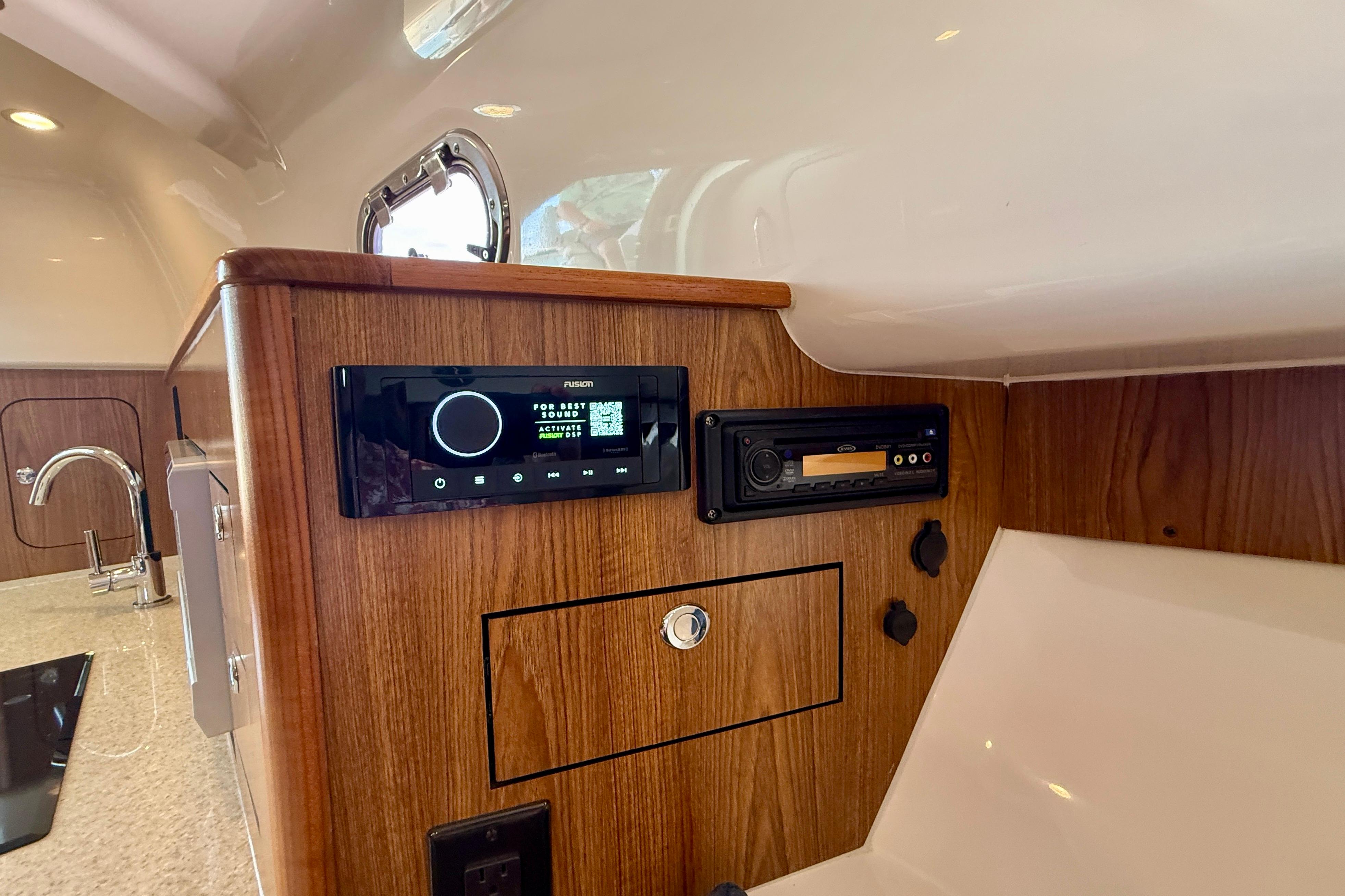 Interior of 2012 Pursuit OS 345 Offshore boat with wood paneling and audio system.