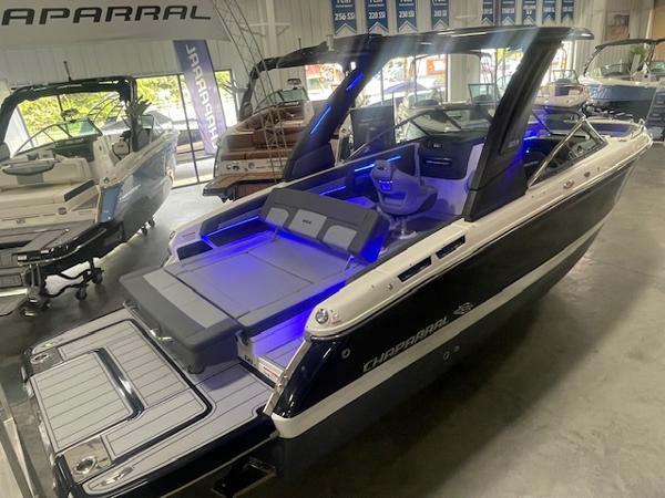 2025 Chaparral 267 SSX boat with blue interior lighting in a showroom.