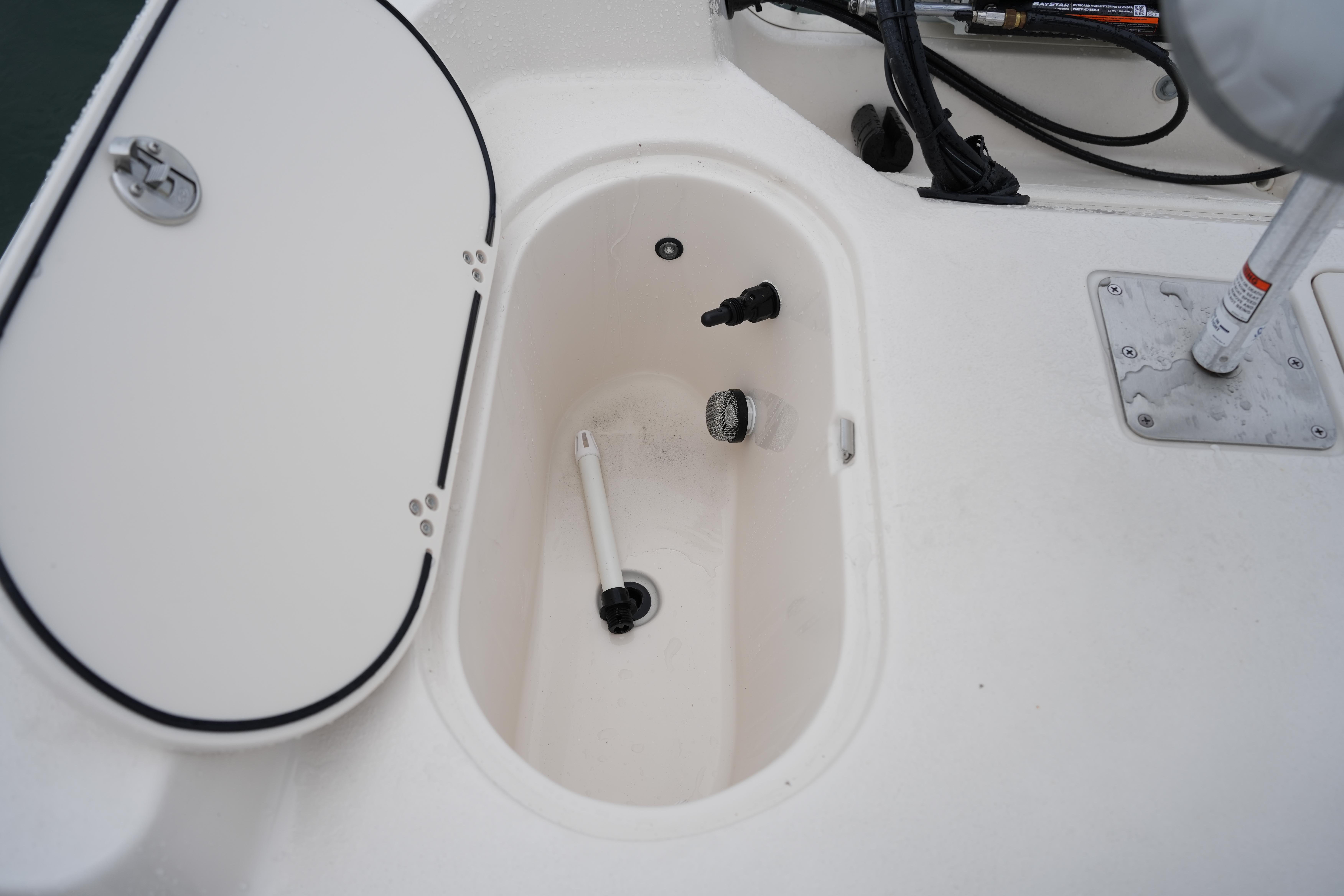 2025 Carolina Skiff 162 JLS boat interior compartment with open hatch and fittings.
