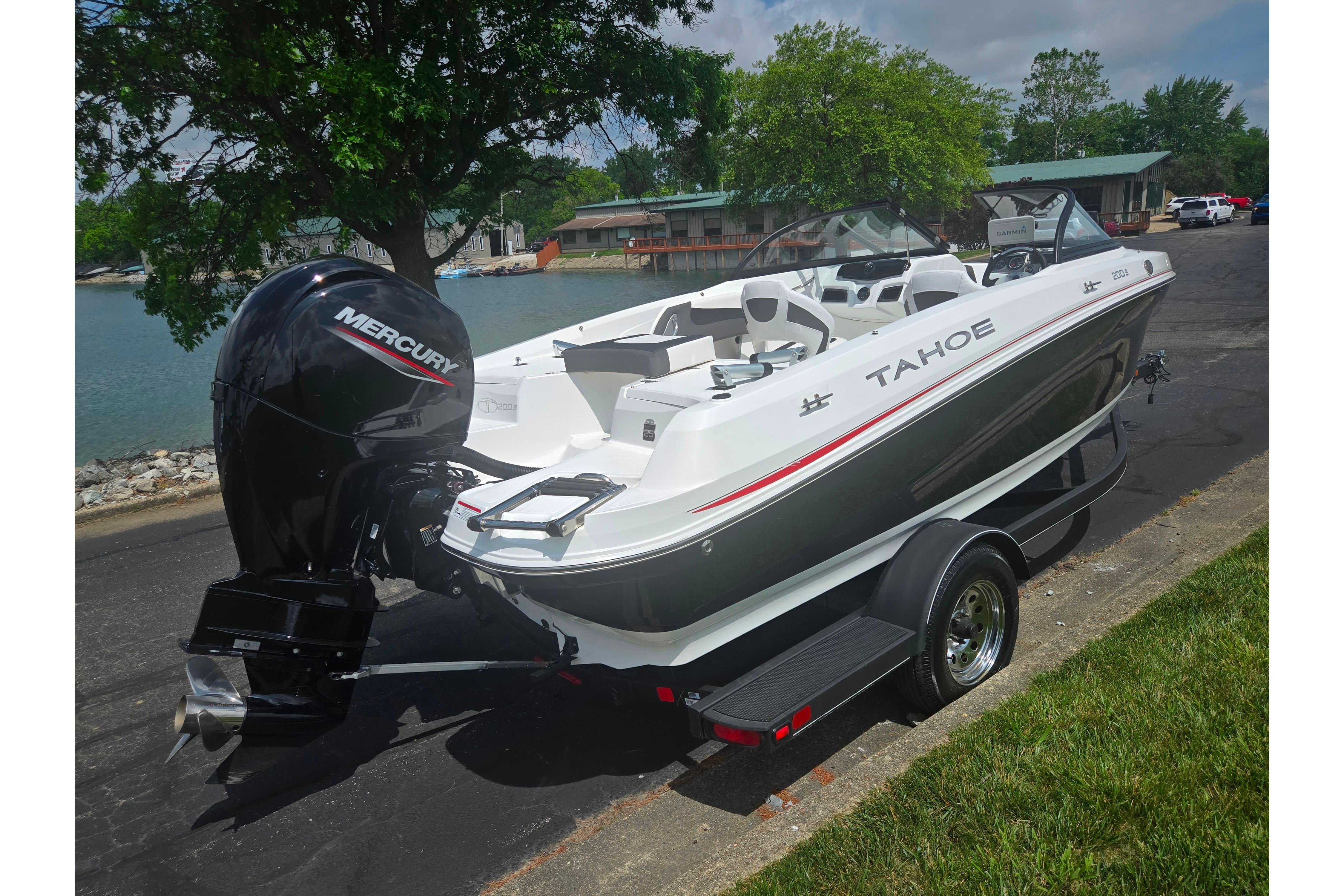 2023 Tahoe 200 S boat with Mercury engine, parked near a lakeside.