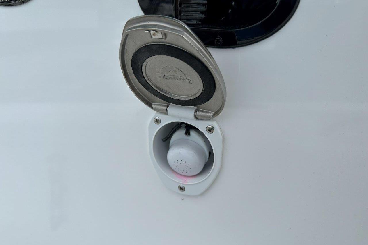 Open hatch on 2026 Tidewater 272 LXF boat, showing a small device inside.
