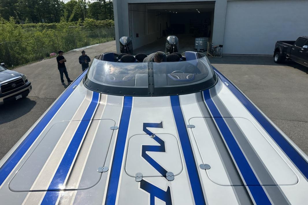 2018 Wright Performance 420 boat with blue and gray stripes, parked outdoors.
