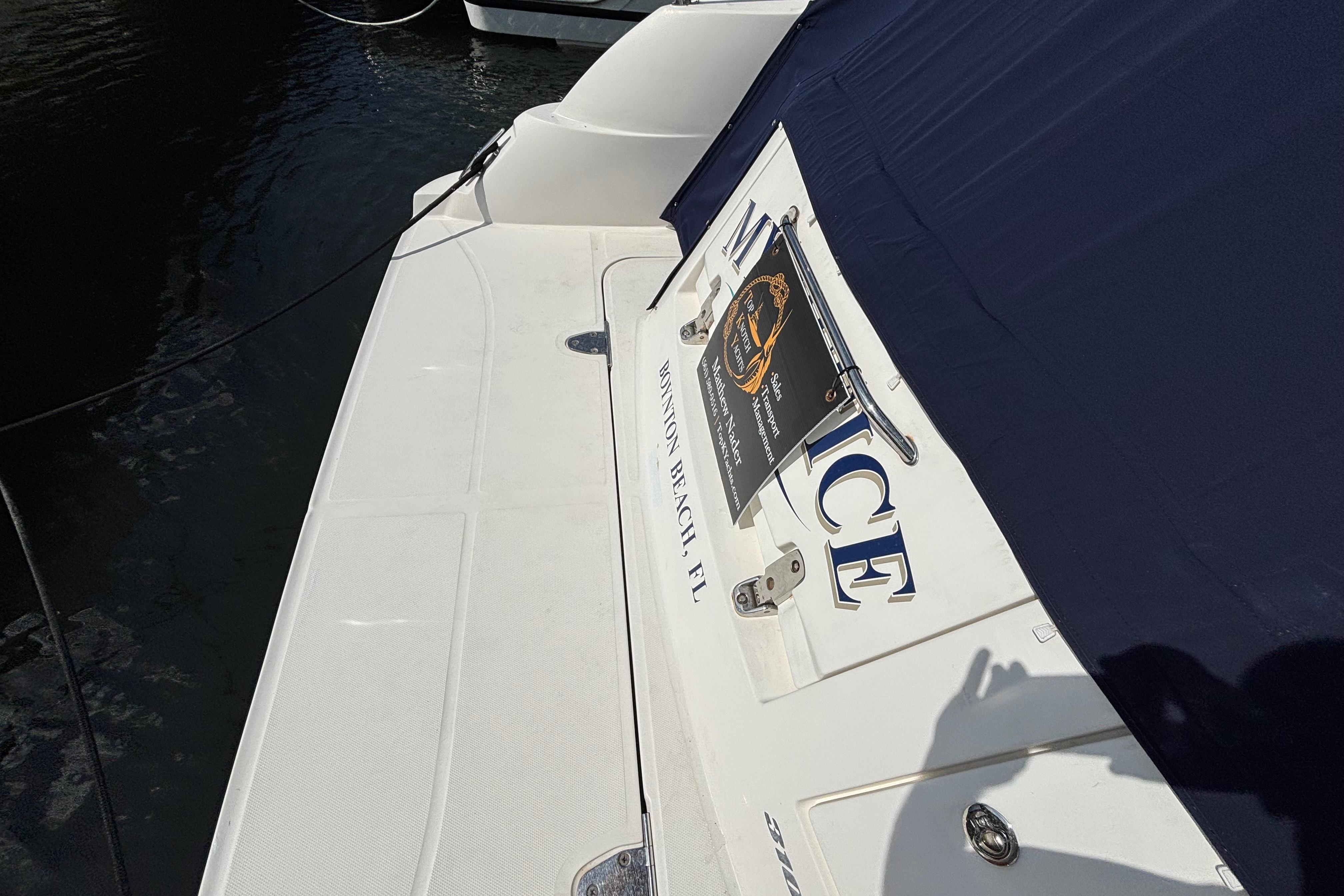 2009 Sea Ray Sundancer 310 boat docked, featuring a white deck and navy cover.