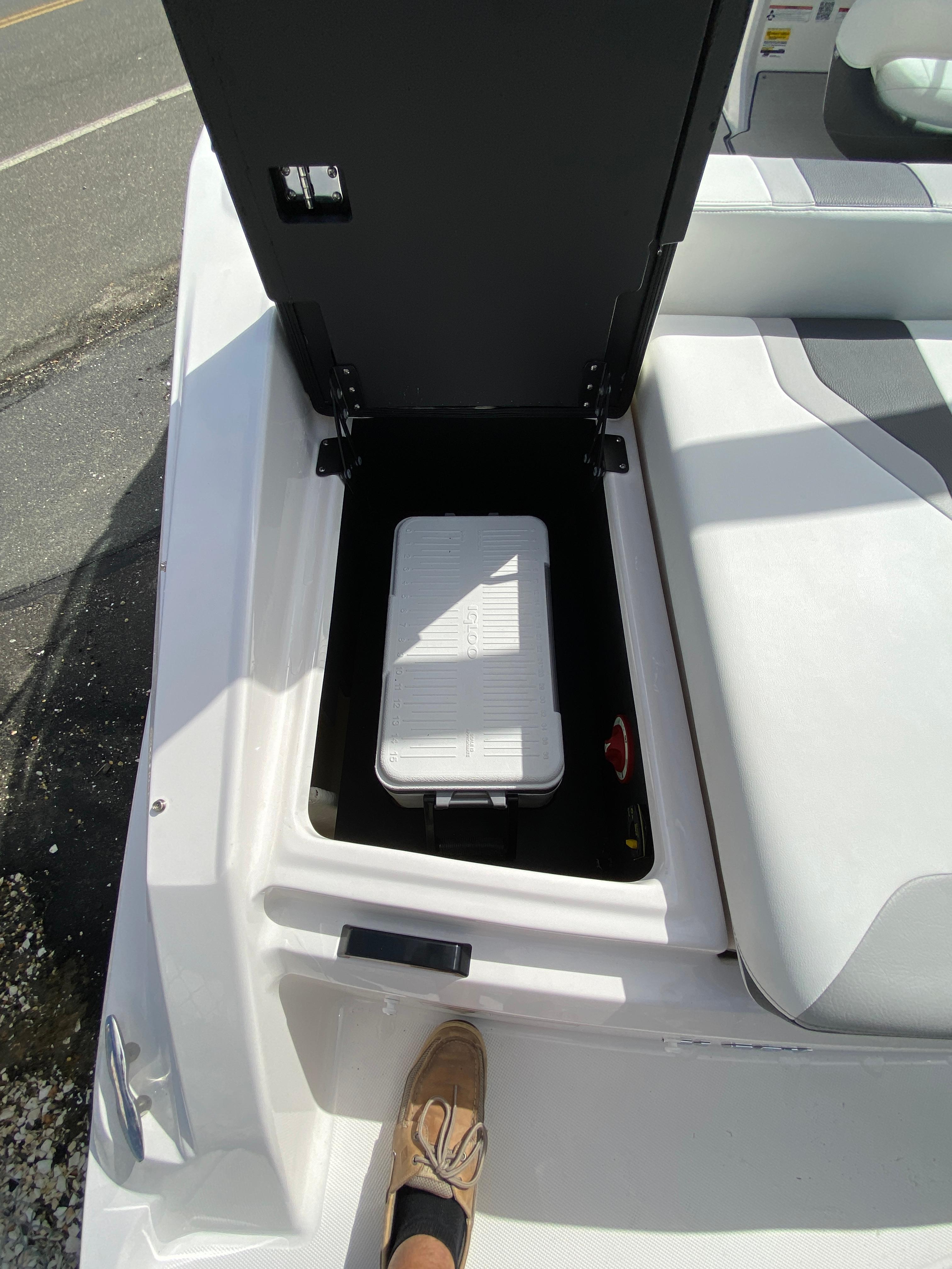 2026 Regal 21 OBX boat storage compartment with cooler and seating area.