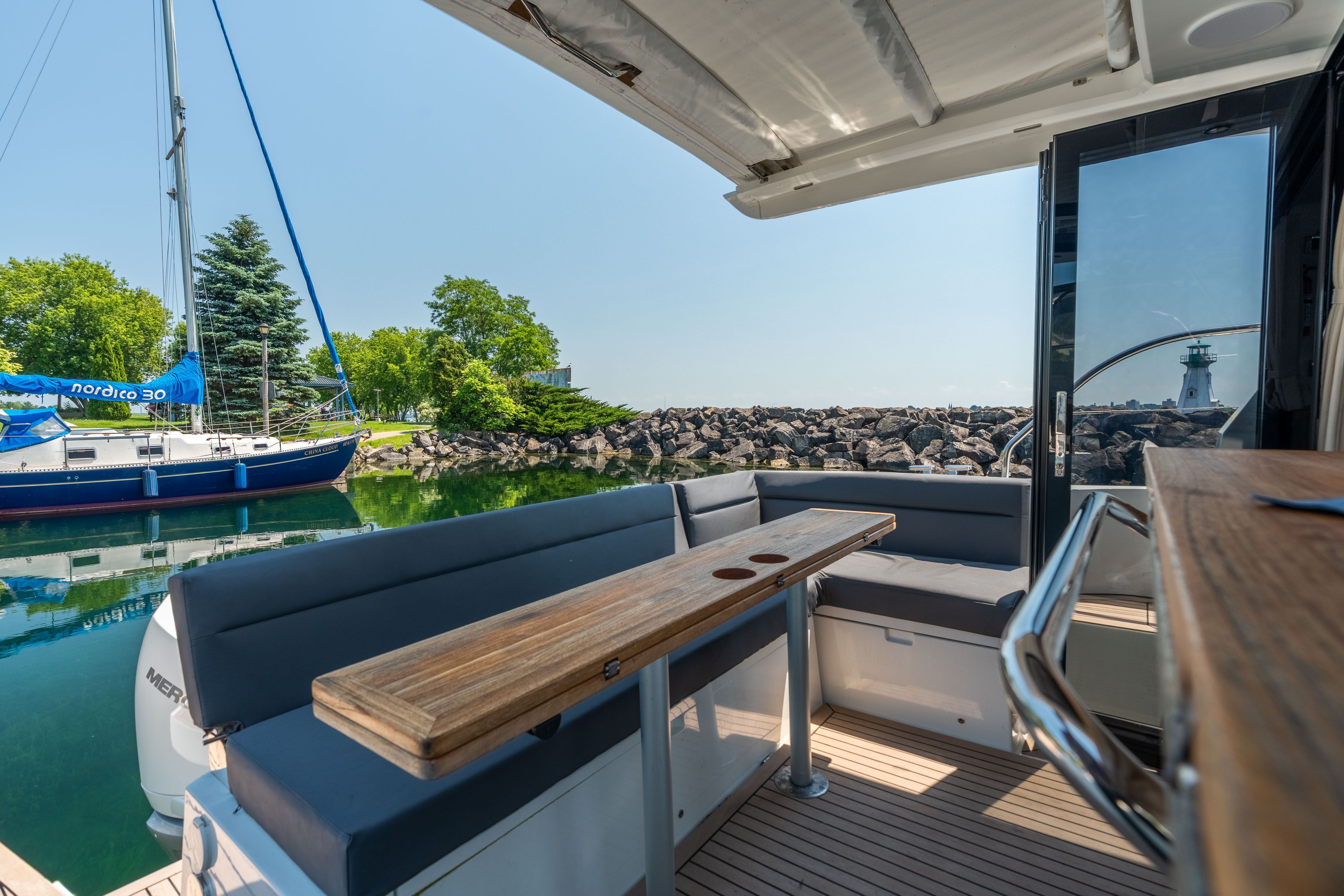 The image shows the aft of a Sealine C335V yacht with seating area and table.
