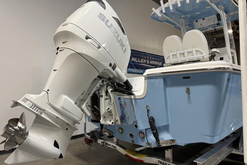 2026 Sea Pro 250 Bay boat with Suzuki outboard motor in showroom.