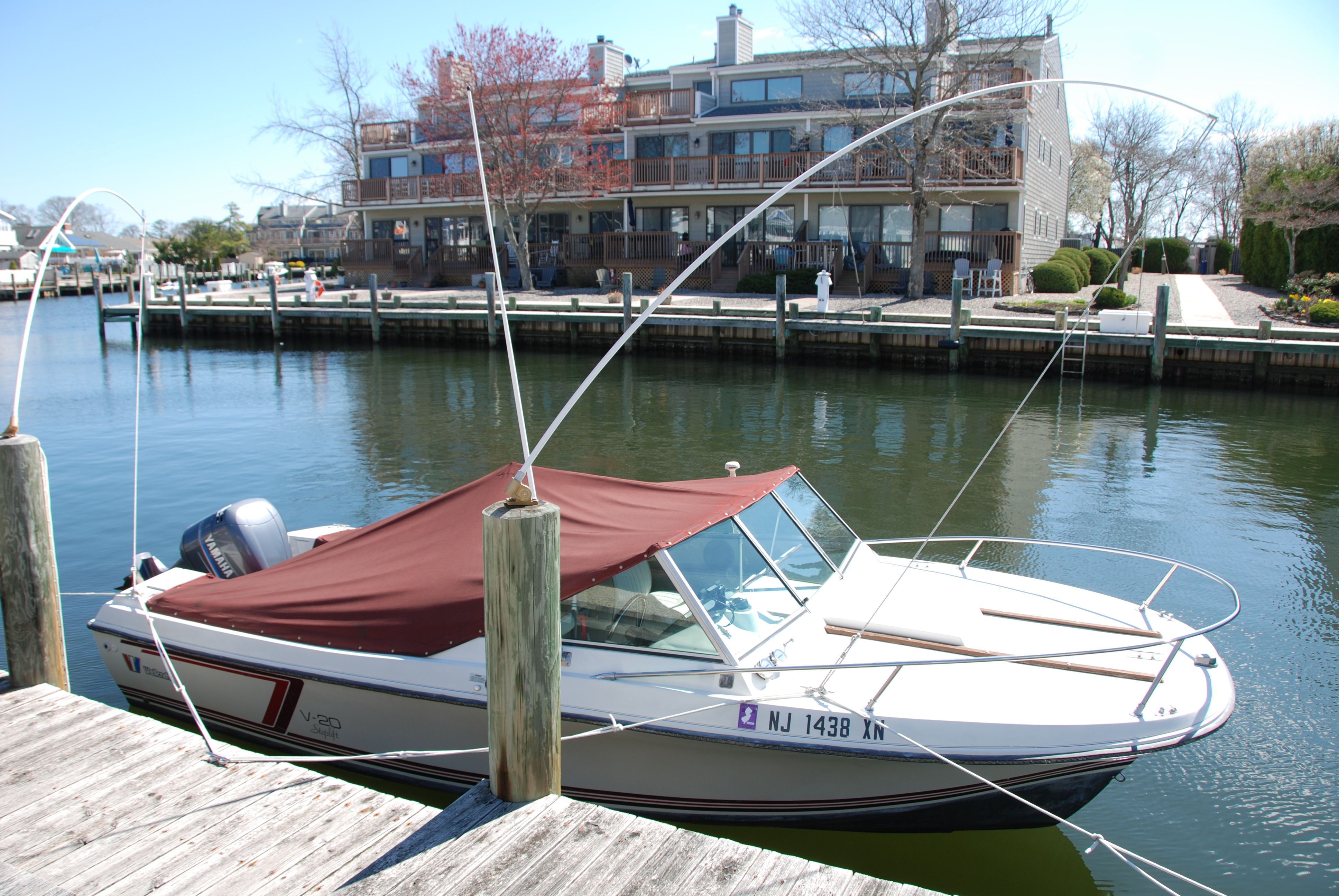 A 1987 Wellcraft V-20 Steplift docked in calm waters, featuring a red canopy.