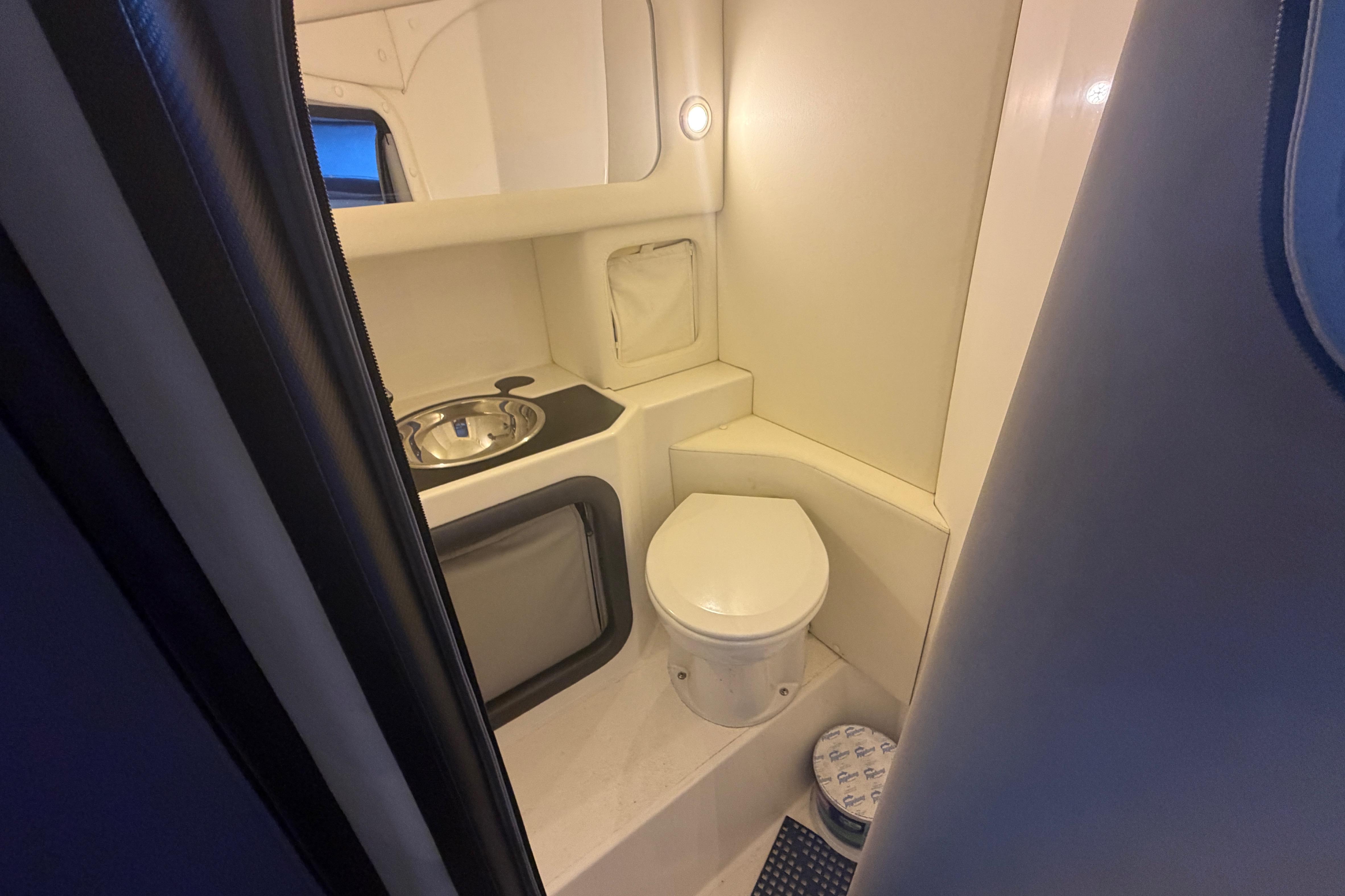 Compact bathroom in 2013 Nor-Tech 477 SPX Vee Bottom boat, featuring toilet and sink.