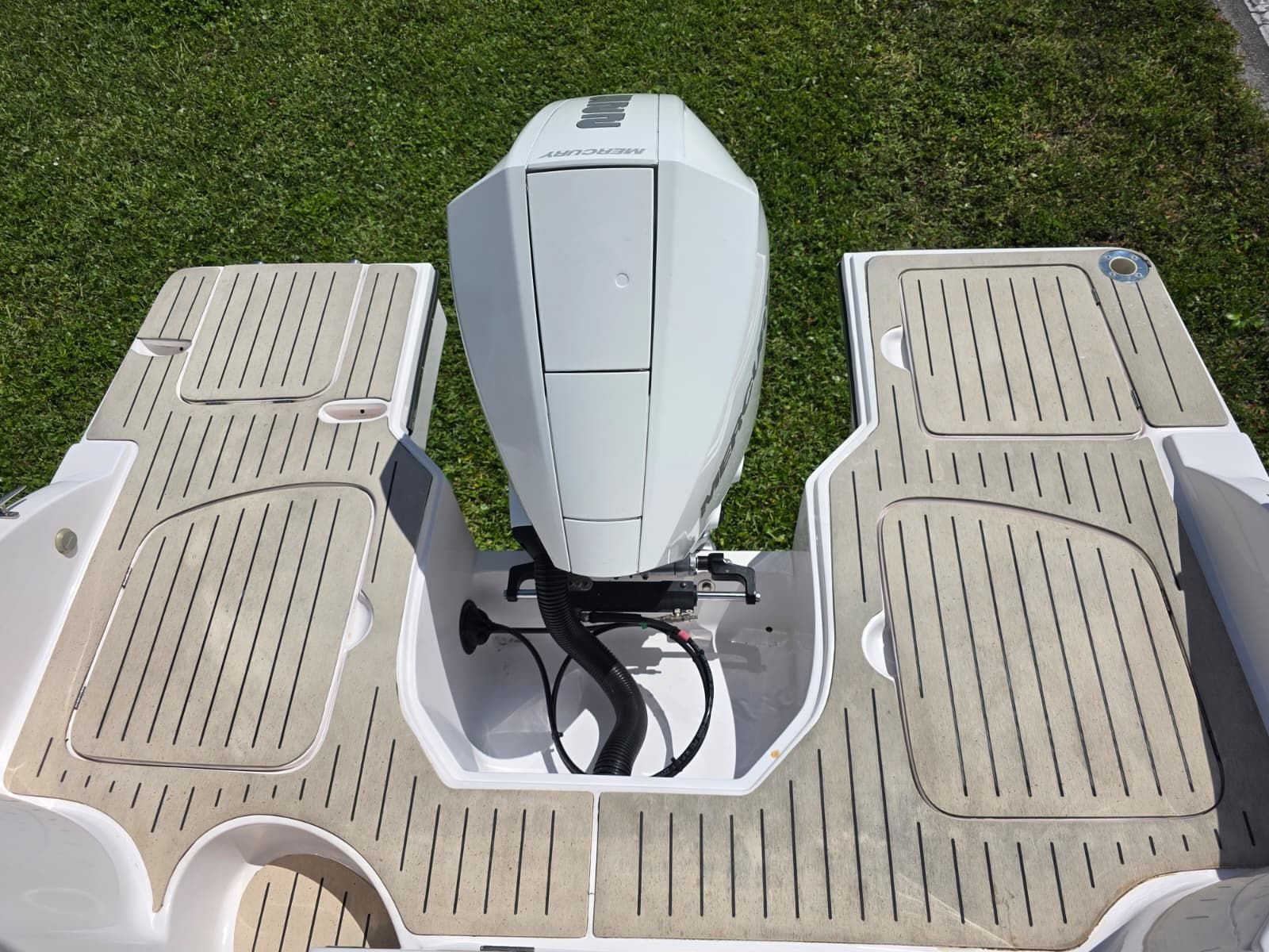 The image shows the stern of a boat with an outboard motor and spacious deck.