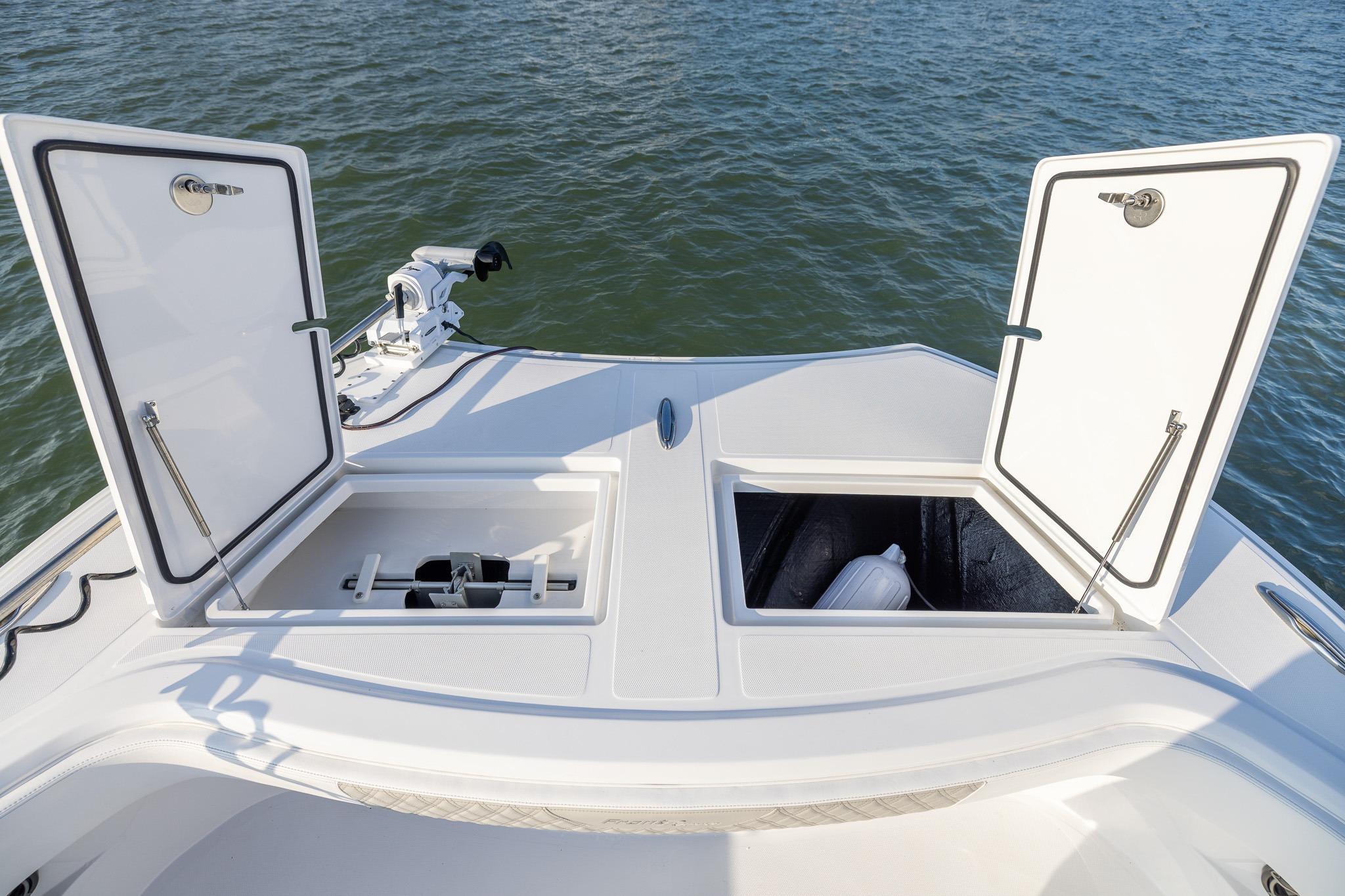 Front Runner 37 Catamaran 2026 with open storage compartments on deck, near water.