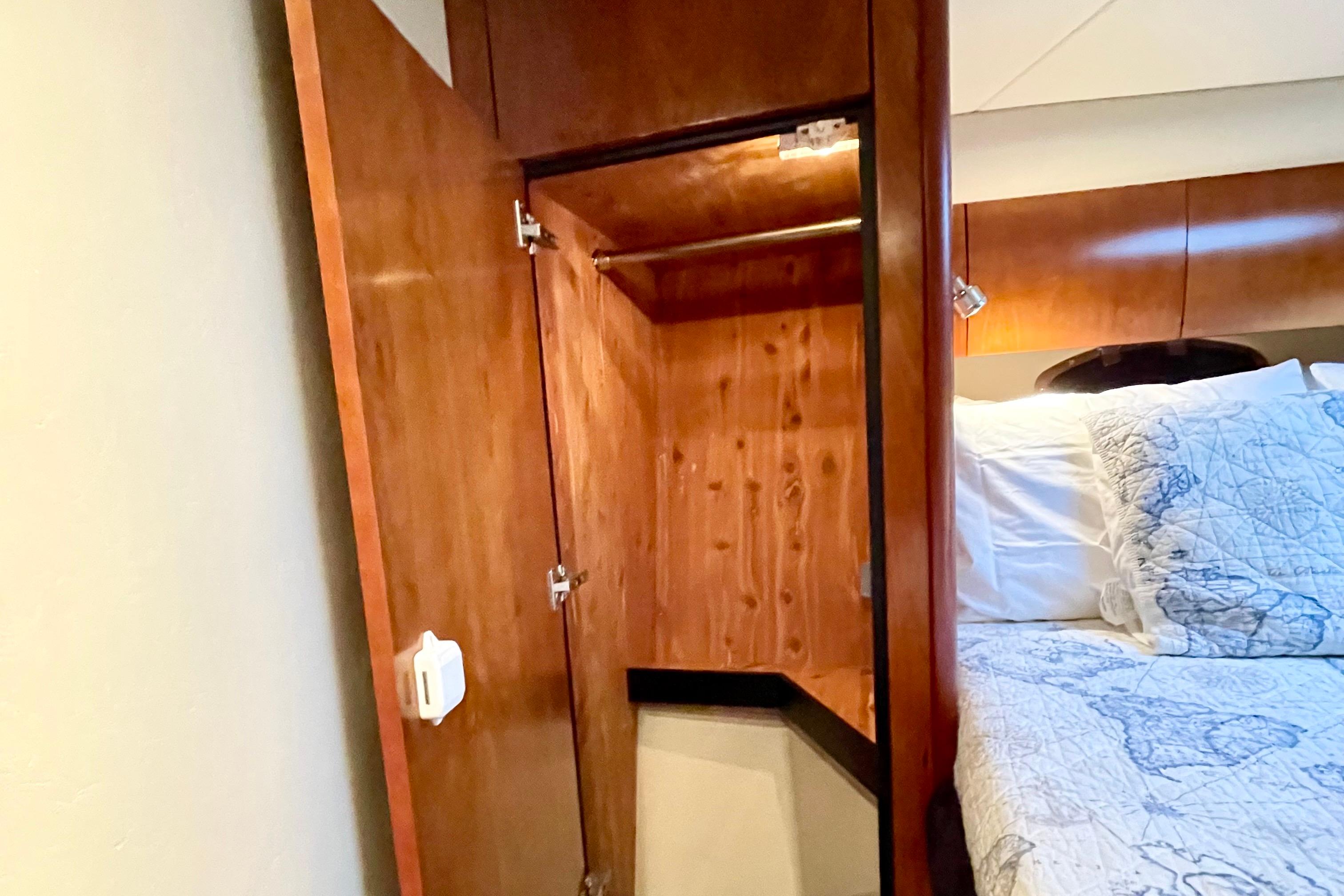 Interior of 2011 Cruisers Yachts 390 Sports Coupe with wooden closet and cozy bedding.