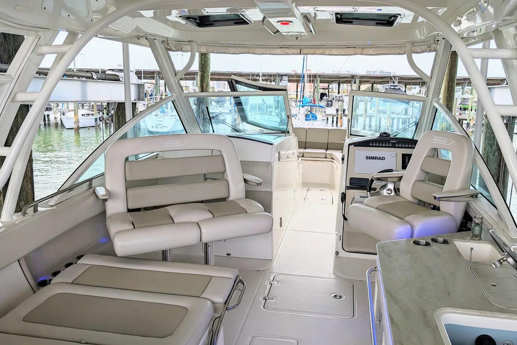 2017 Boston Whaler 320 Vantage interior with seating and helm, docked at marina.