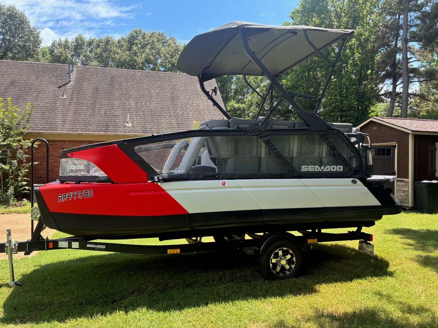 A 2023 Sea-Doo Switch Sport 18 on a trailer in a backyard setting.