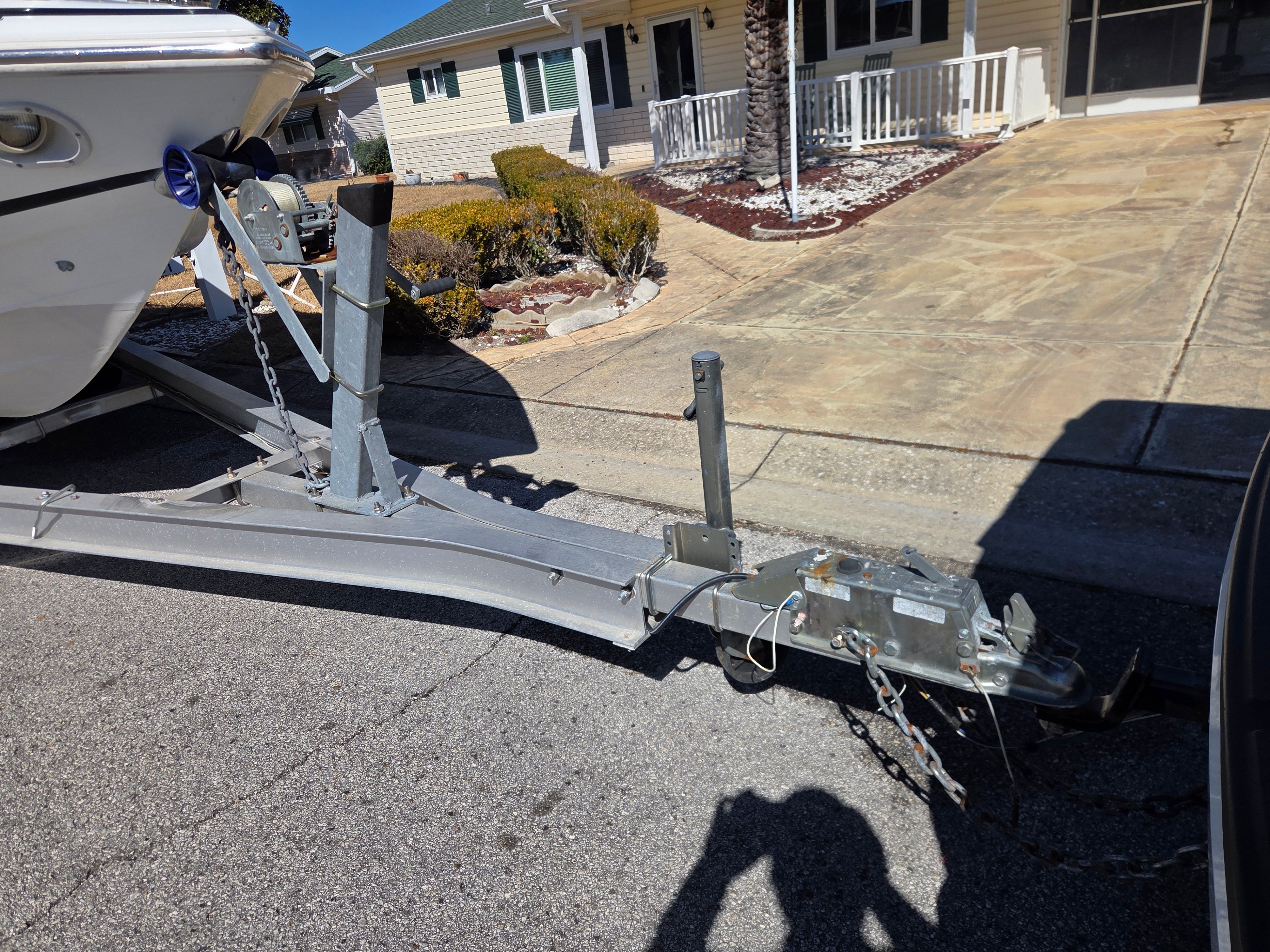 Boat trailer with Cobalt 23LS, 1997, parked on street.