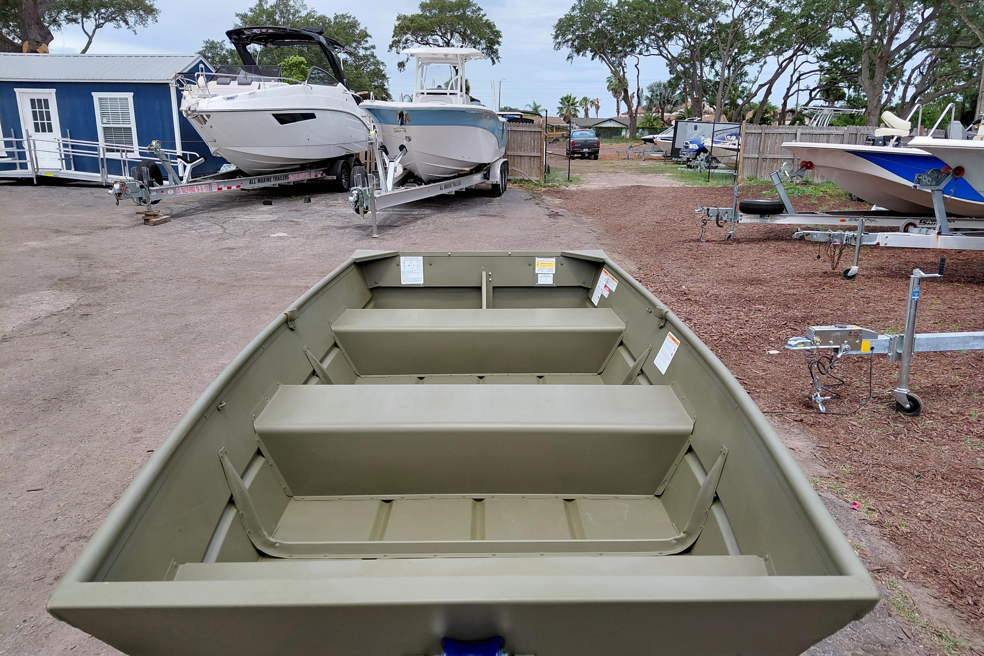 2025 Lowe L1040 Jon boat in a marina with other boats and trailers.