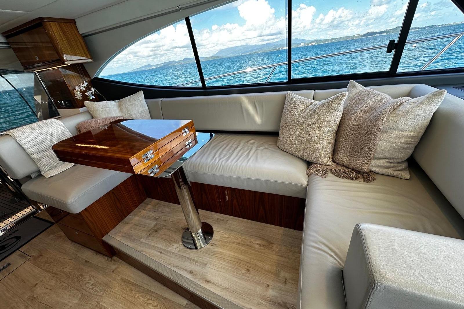Luxurious interior of 2023 Riviera 465 SUV yacht with plush seating and ocean view.