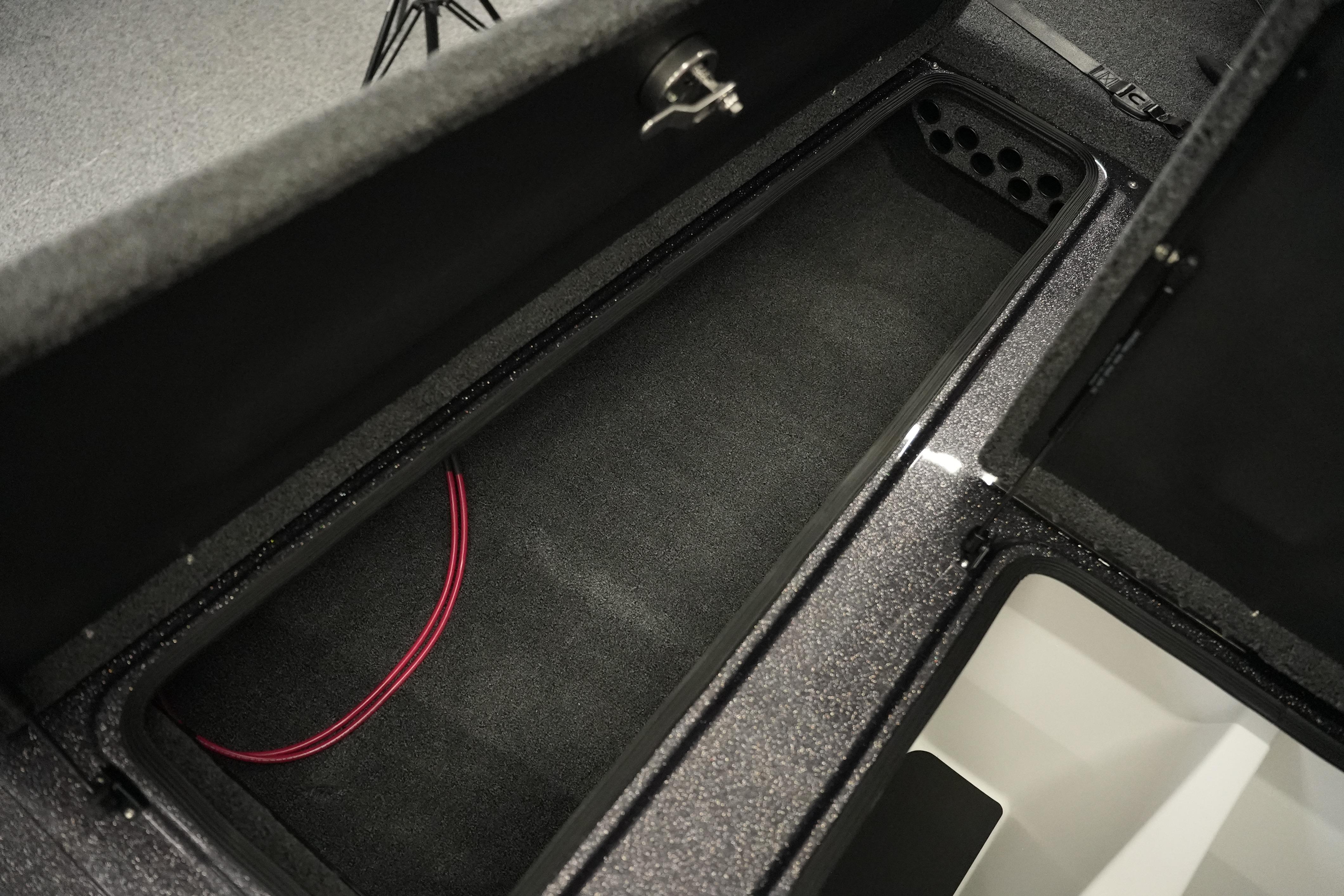 Storage compartment of 2026 Bass Cat Puma STS boat, featuring carpeted interior and wiring.
