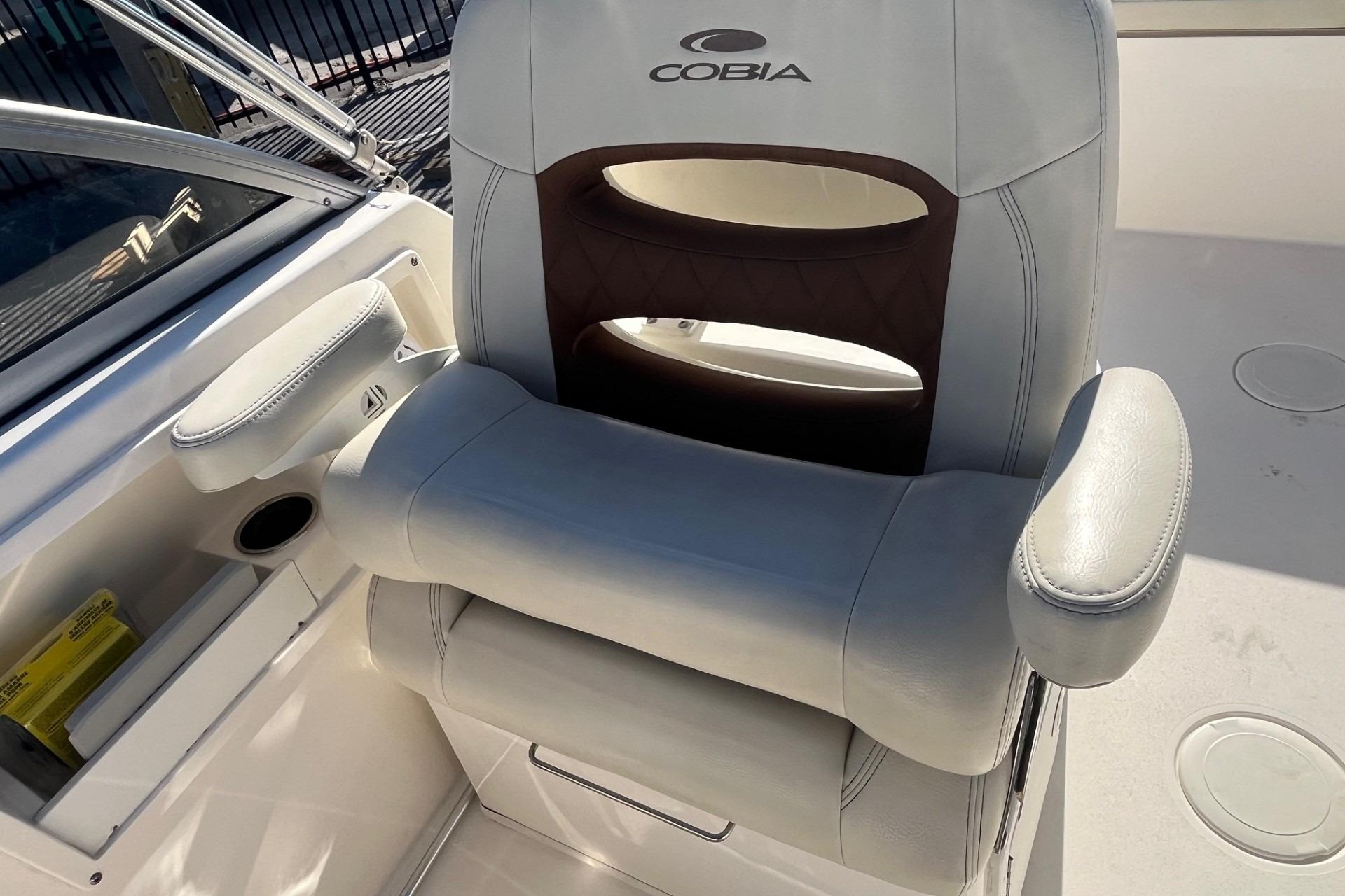 Captain's chair on 2023 Cobia 220 Dual Console boat, featuring comfortable armrests and sleek design.