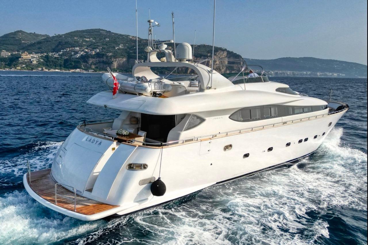 Luxury Maiora 29 DP yacht cruising on the ocean, 2000 model, scenic coastal backdrop.