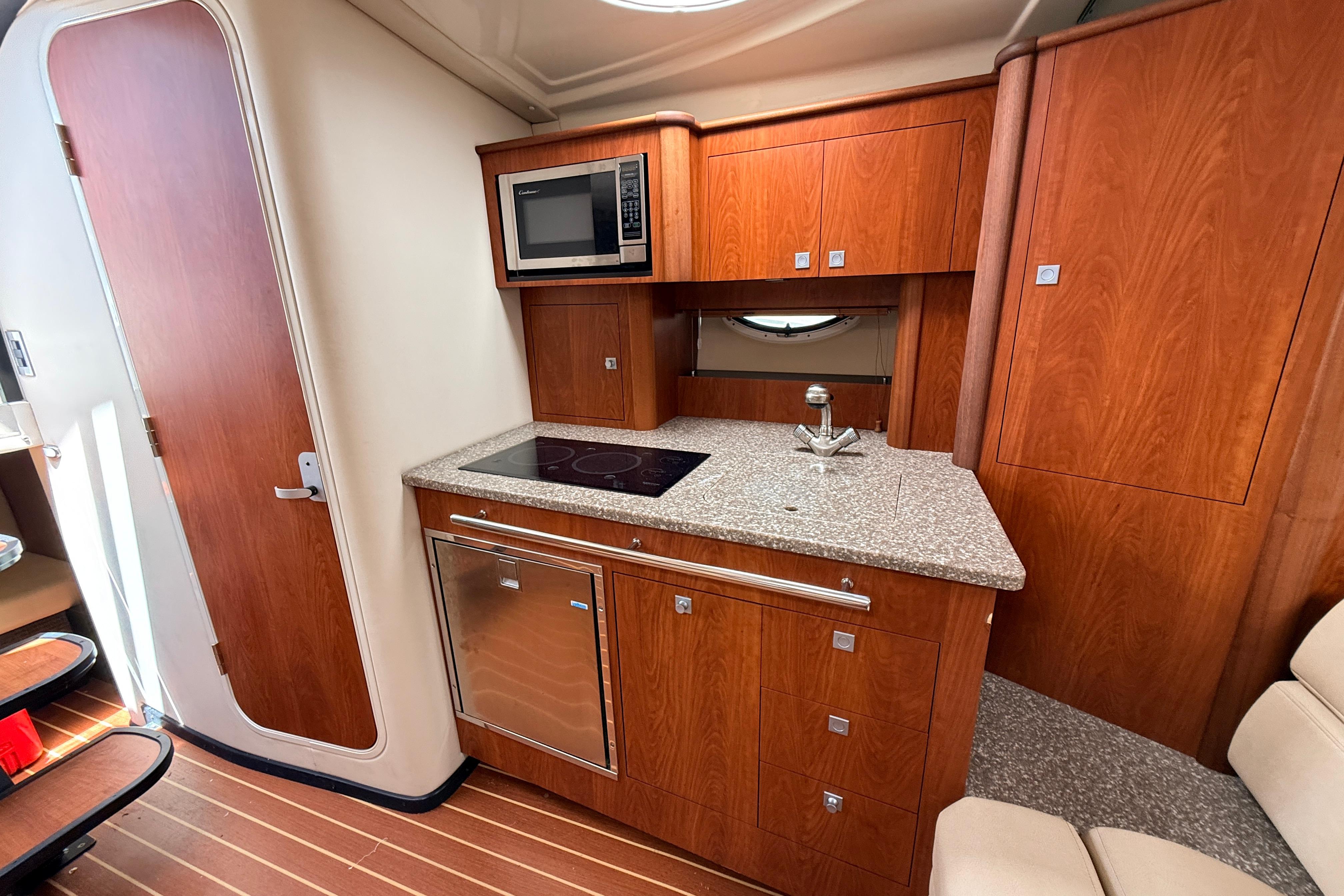 Luxurious 2011 Monterey 320 Sport Yacht kitchen with wood cabinetry and modern appliances.