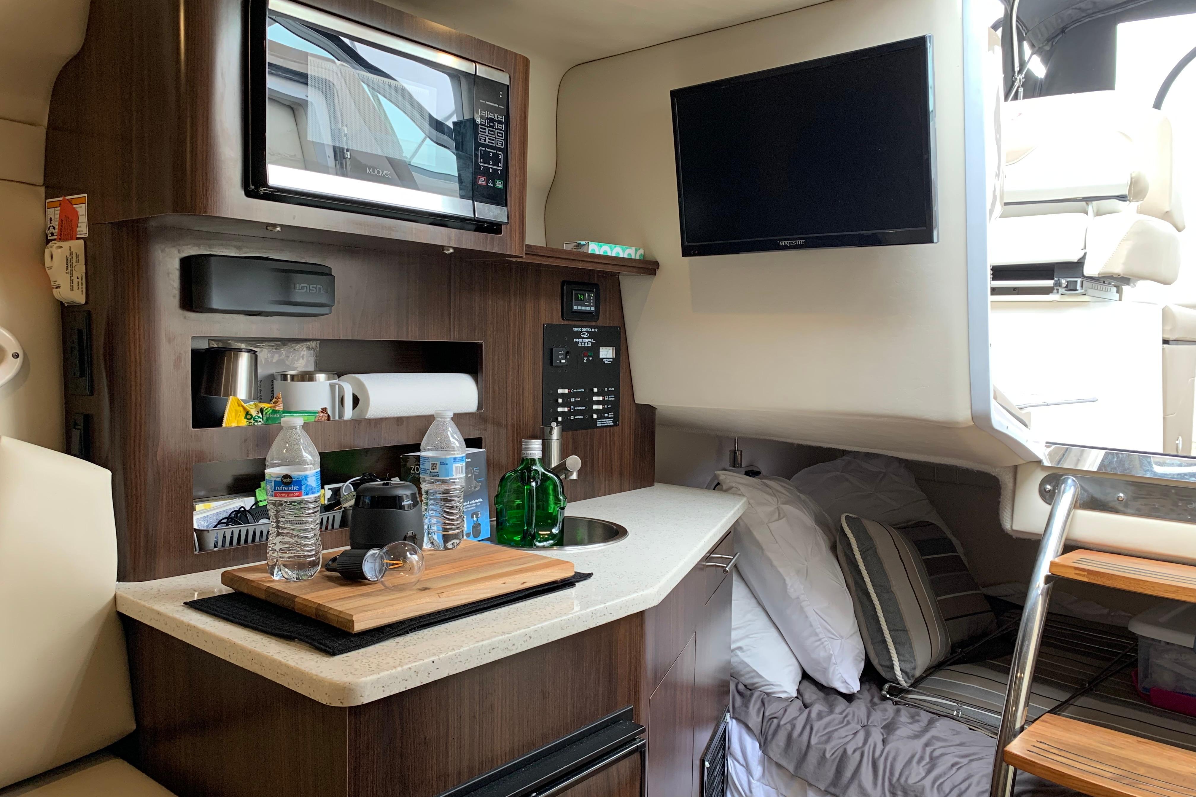 Interior of 2017 Regal 26 Express boat with kitchenette and cozy sleeping area.