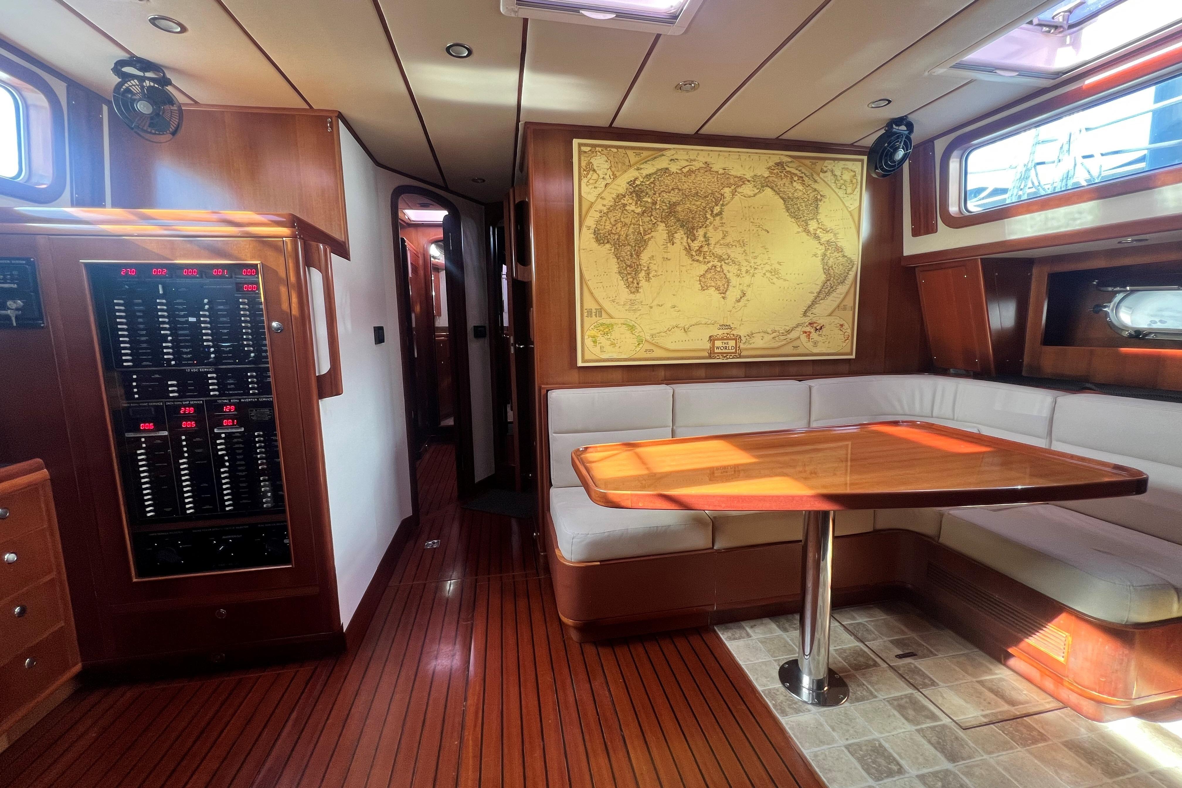 Luxurious 2009 Nordhavn 56 Motorsailer interior with map, wood paneling, and seating area.