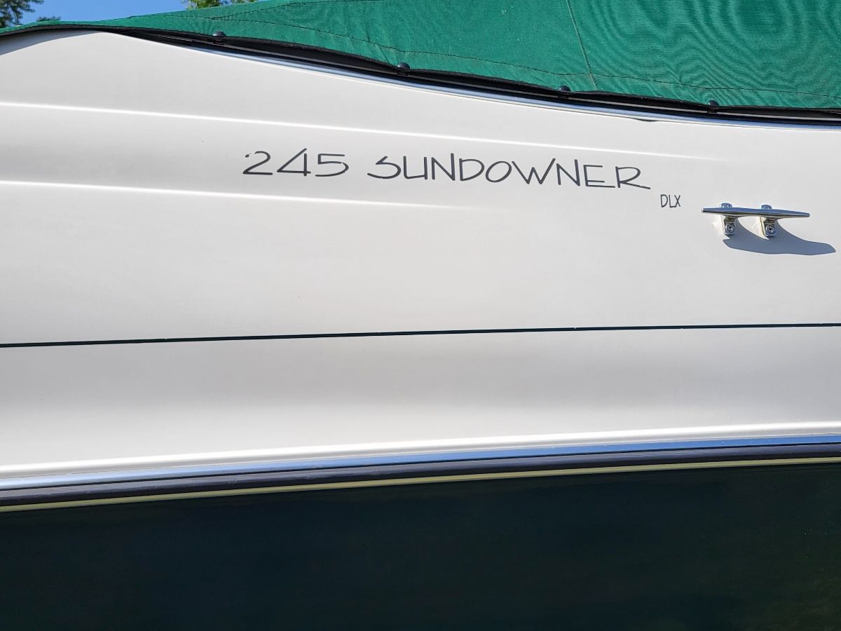 Side view of the 1996 Four Winns 245 Sundowner with a green cover.