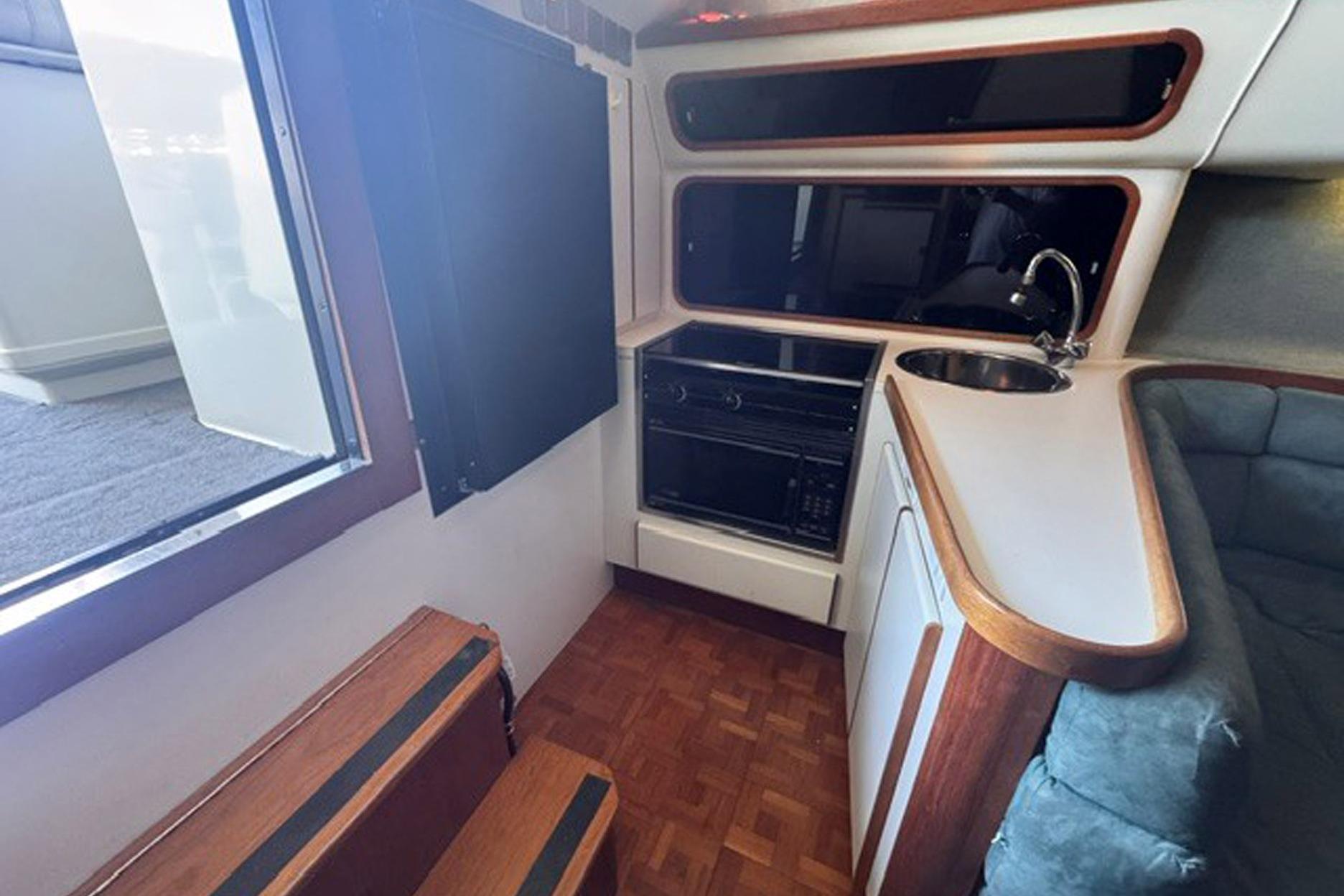 1988 Tiara Yachts 3300 Open interior with compact kitchen and seating area.
