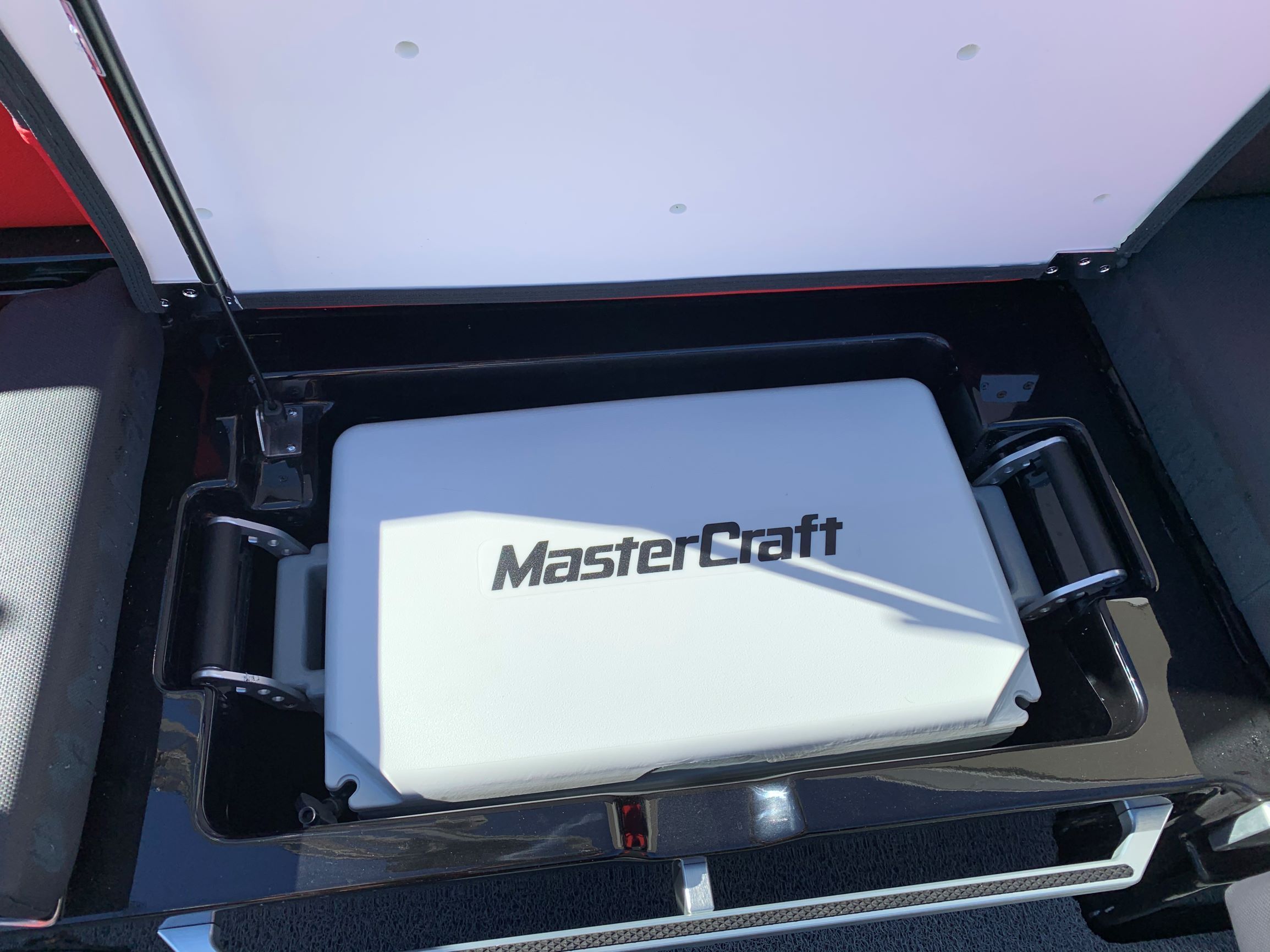 A 2020 MasterCraft X24 with an open storage compartment lid.