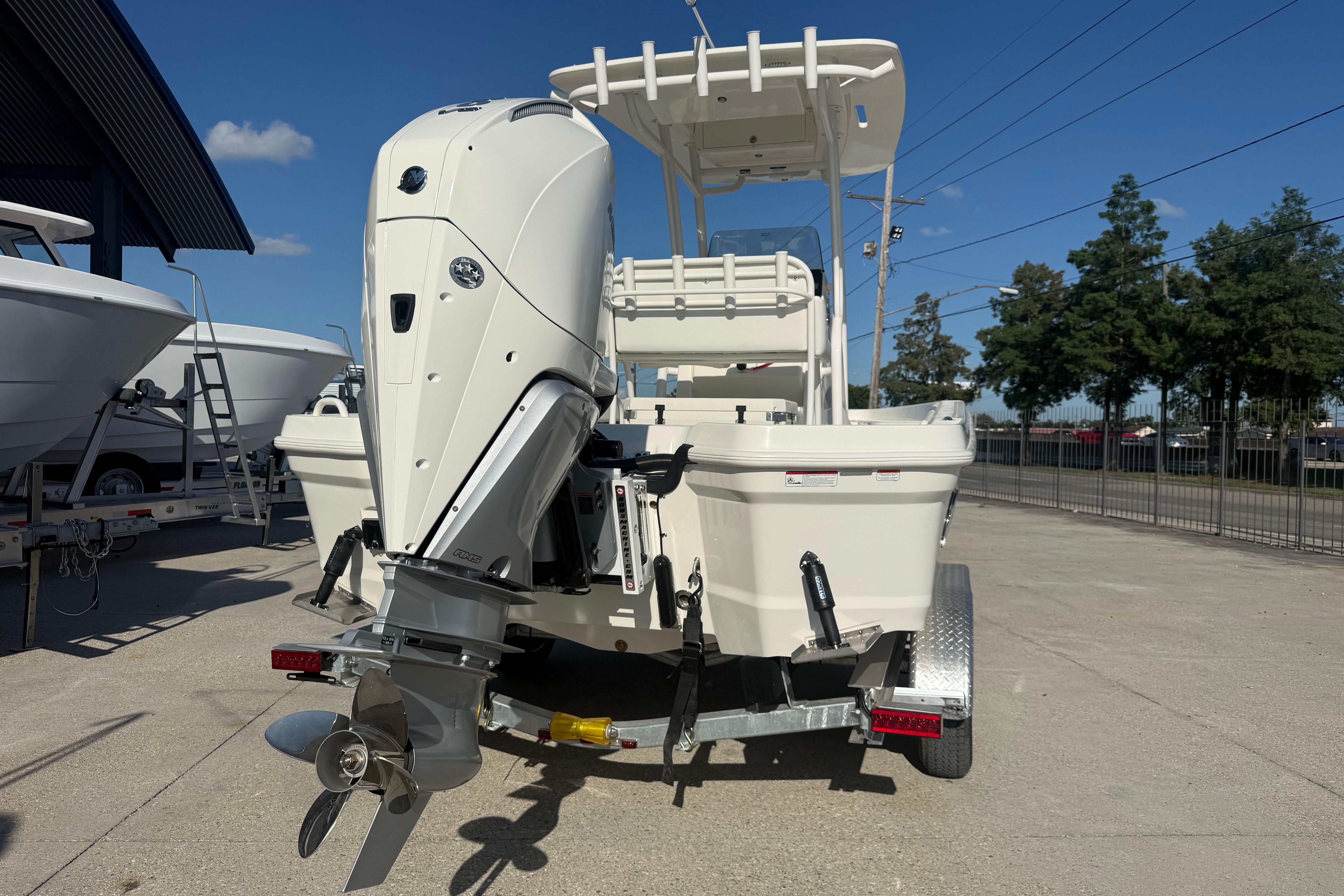 2026 Mako 24 APEX boat on trailer, featuring powerful outboard motor, parked outdoors.