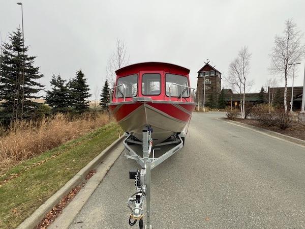 2024 Spartan 220 Maximus boat on trailer, parked on a suburban road.