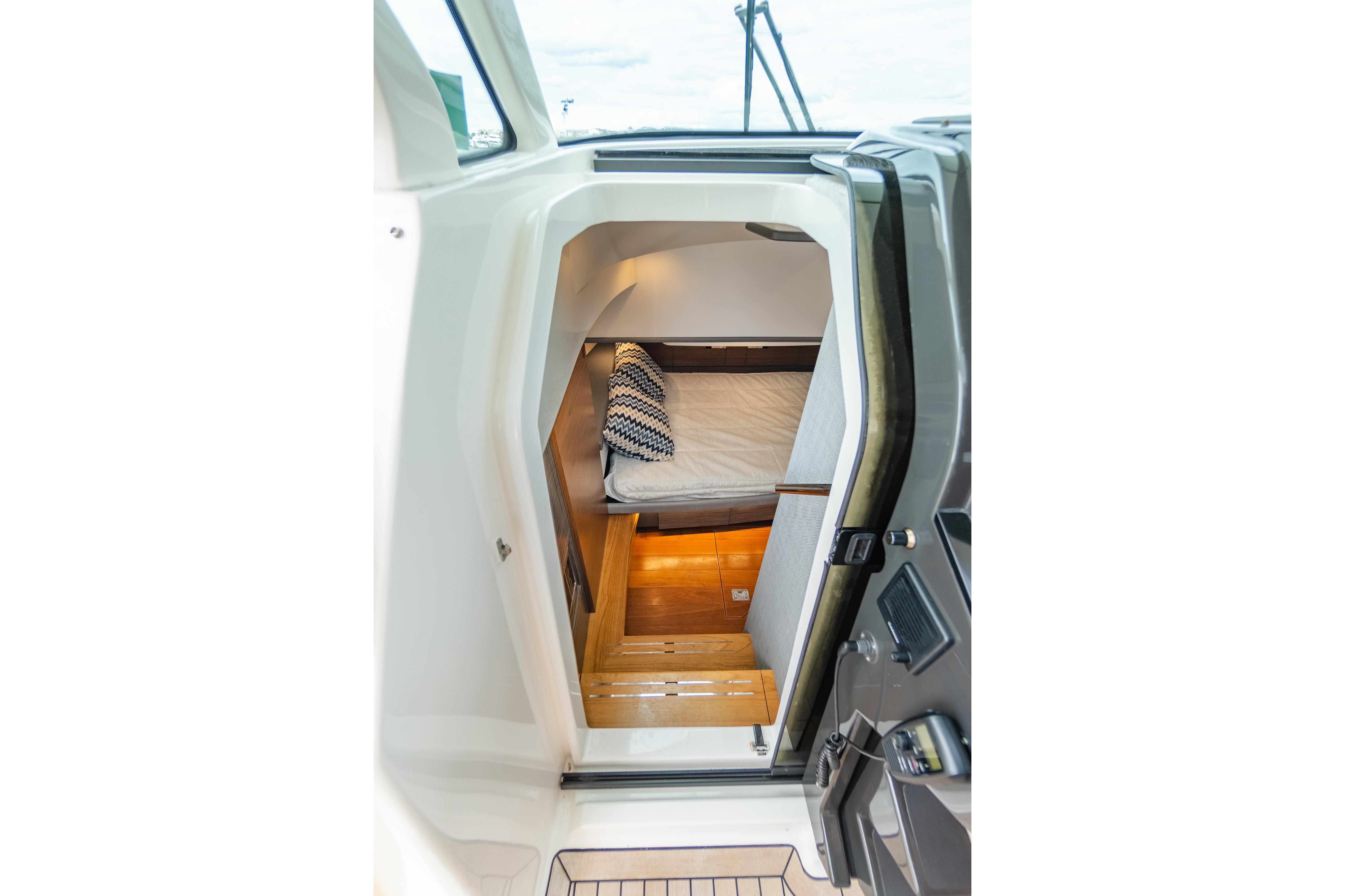 2020 Tiara Sport 38 LS cabin interior with cozy bed and wooden flooring.