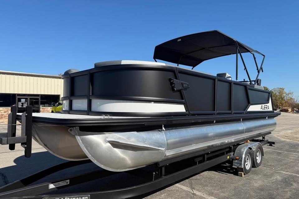 2026 Alera M 25Q pontoon boat on trailer under clear blue sky.